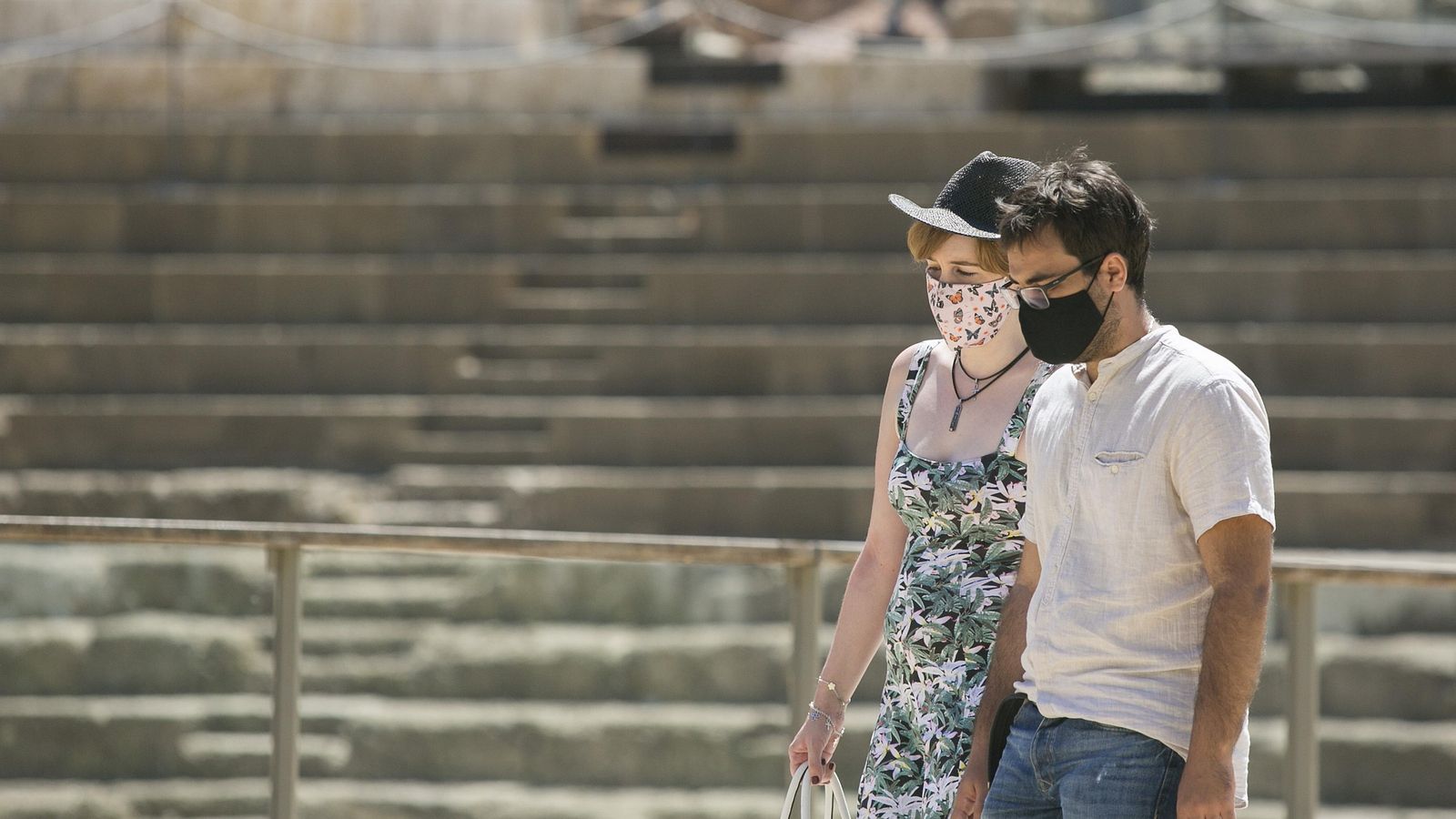 Turistas con mascarilla, frente al teatro romano de Málaga.