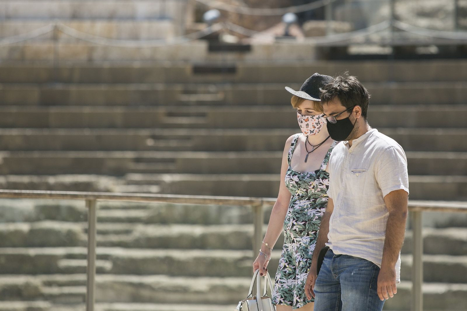 Turistas con mascarilla, frente al teatro romano de Málaga.