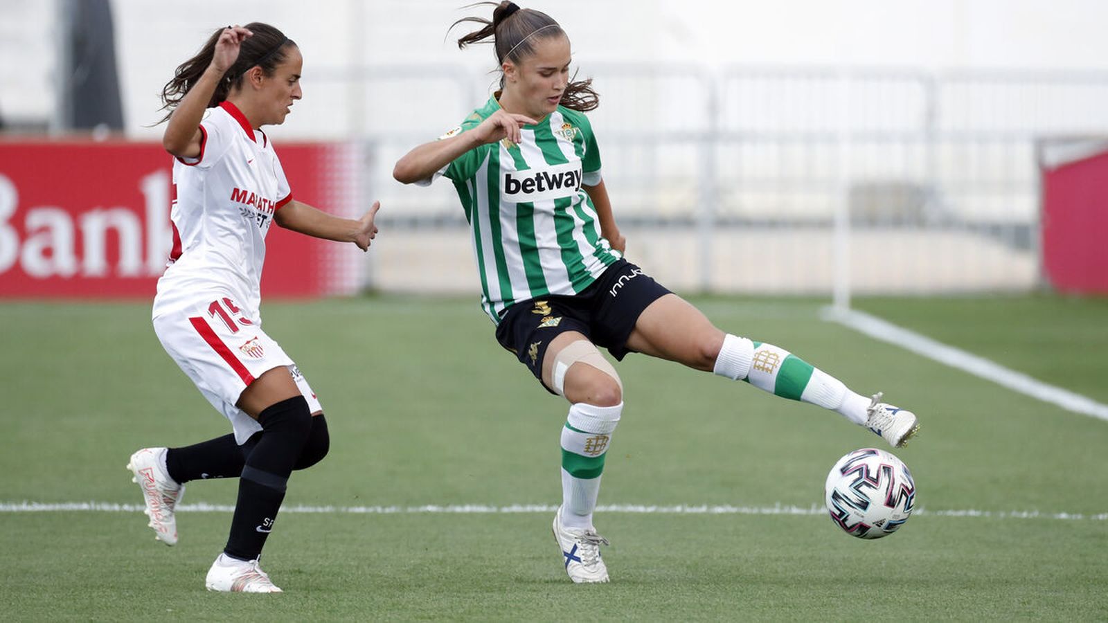 La sevillista Amparito y la bética Medina, en el último Sevilla-Betis, en la ciudad deportiva.