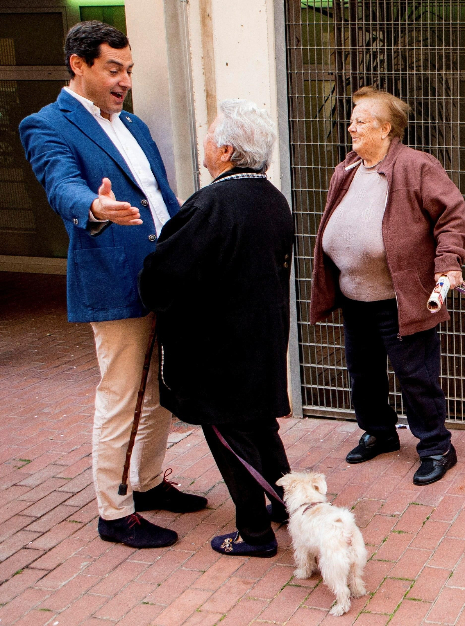Juanma Moreno saluda a dos vecinas en Barcelona.