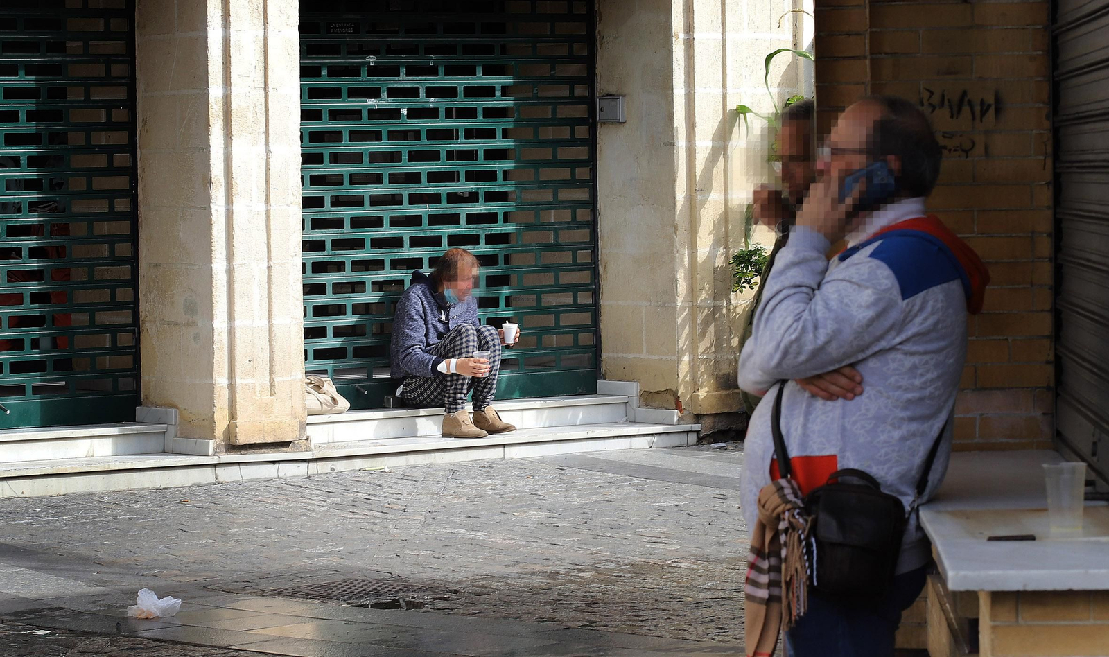 Un hombre pide ayuda en la entrada de un establecimiento cerrado.