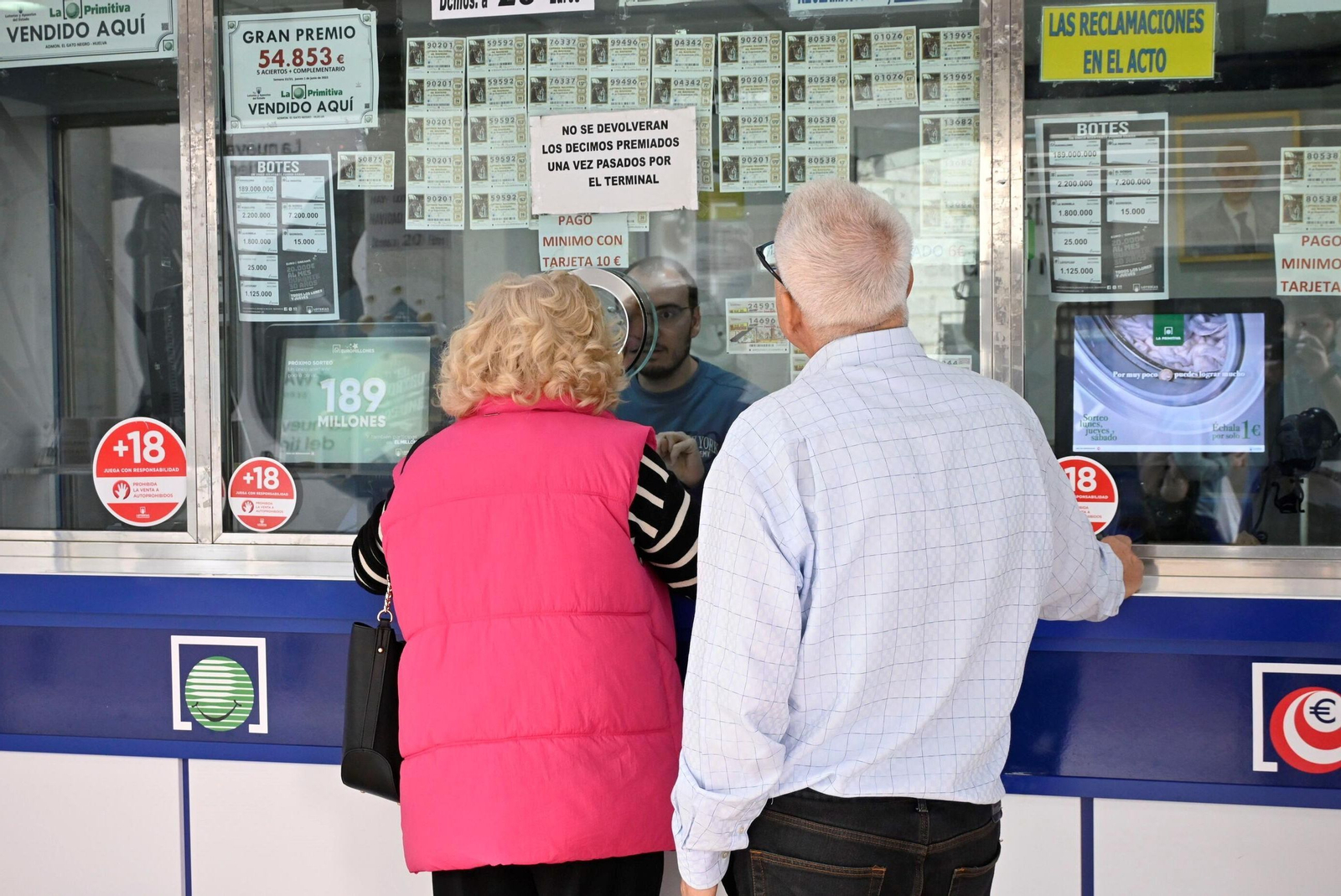 Dos personas compran un décimo de lotería en la administración El Gato Negro de Huelva.