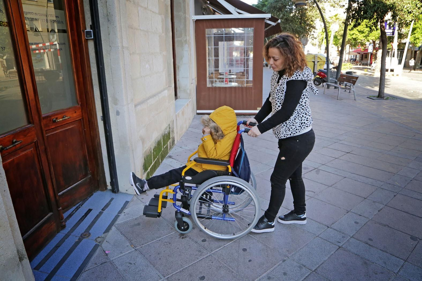 Lorena Moreno  empuja la silla de ruedas de su hijo.