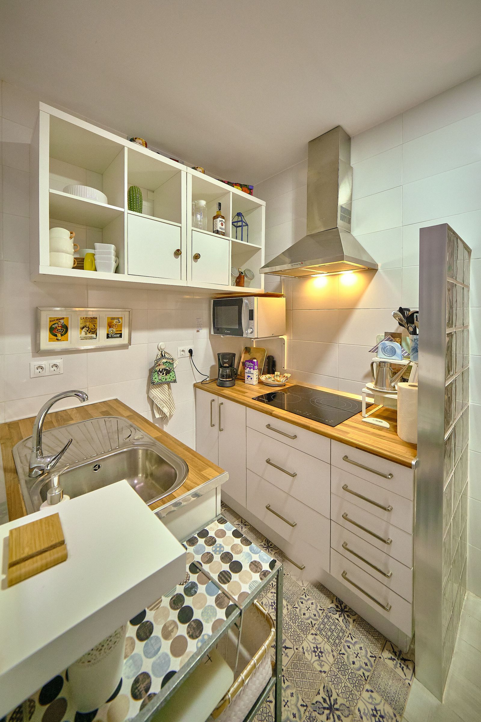 Cocina.  La encimera de madera se mezcla con el blanco y acero de sus muebles.