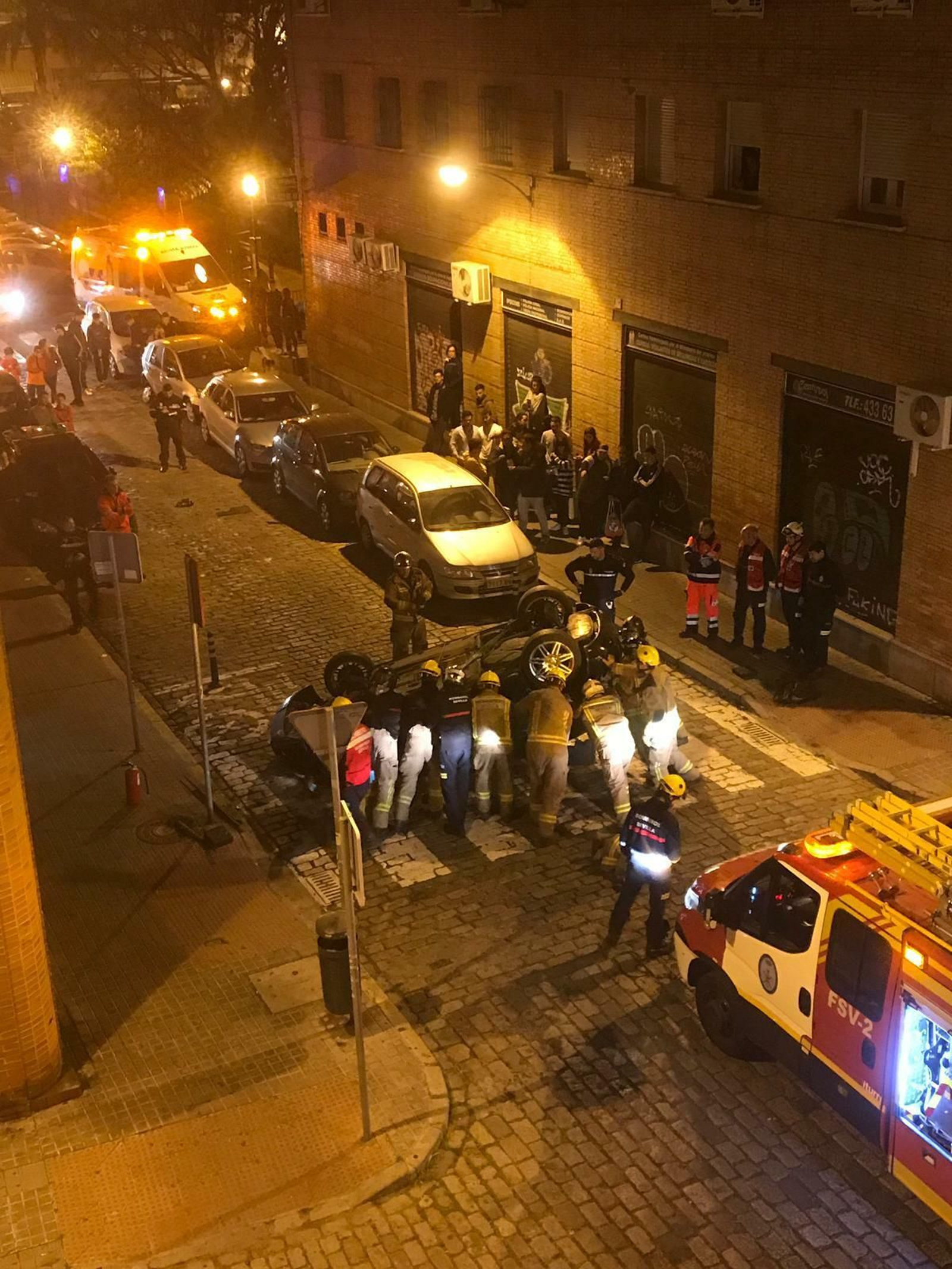 Los bomberos y la Policía Local trabajan para dar la vuelta al vehículo accidentando.