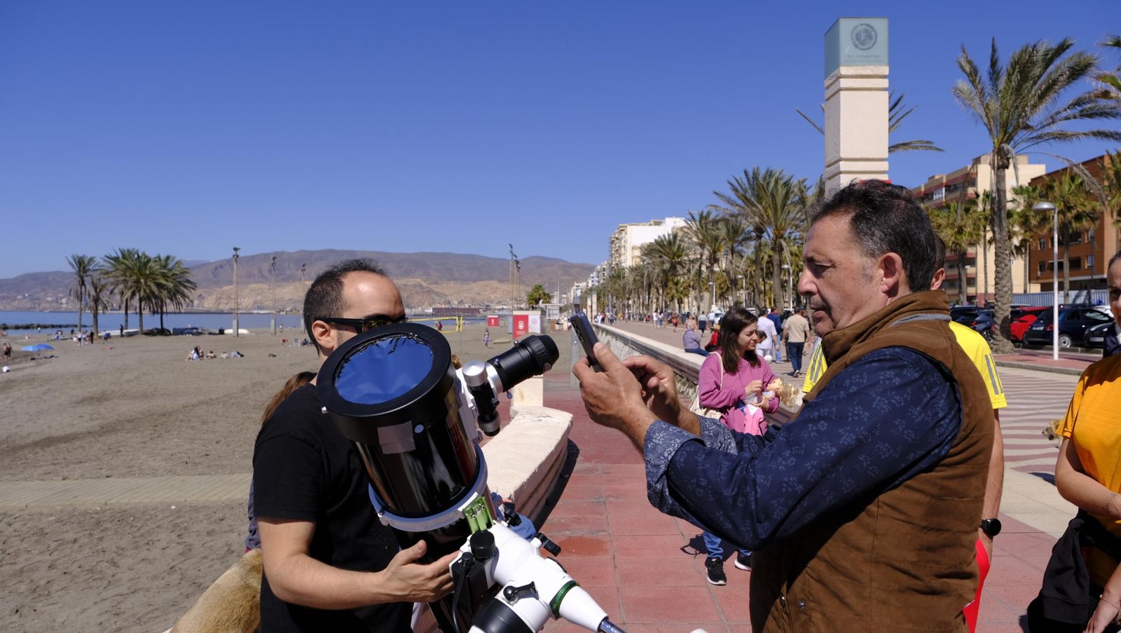 Almería observa el eclipse solar desde el Paseo Marítimo, en imágenes