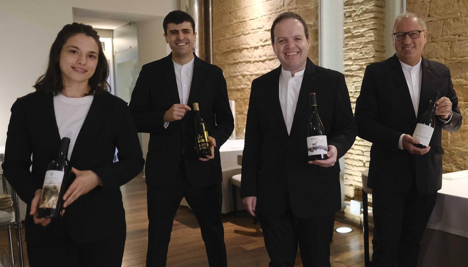 Persona de sala mostrando diferentes vinos rondeños.