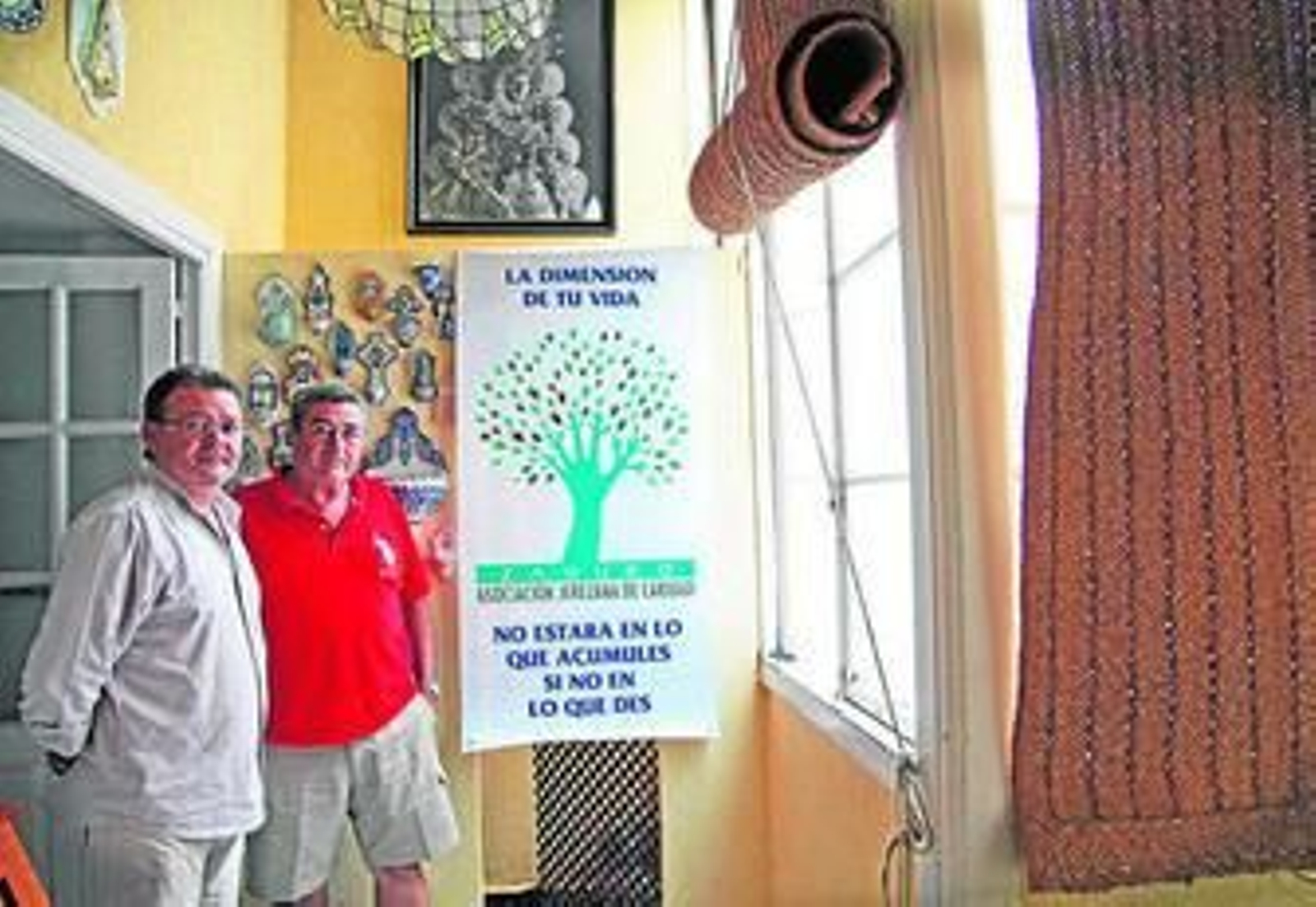 Dos de los fundadores de 'Zaqueo', junto al cartel de la asociación, días atrás.