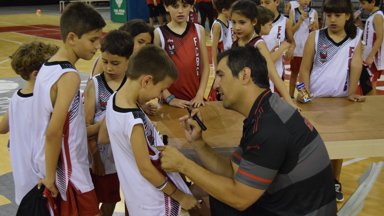 Pablo Pin firma un autógrafo en la camiseta de un niño