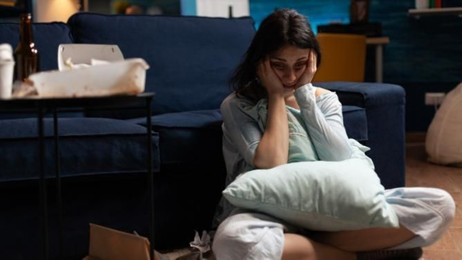 Mujer triste sentada en el suelo.