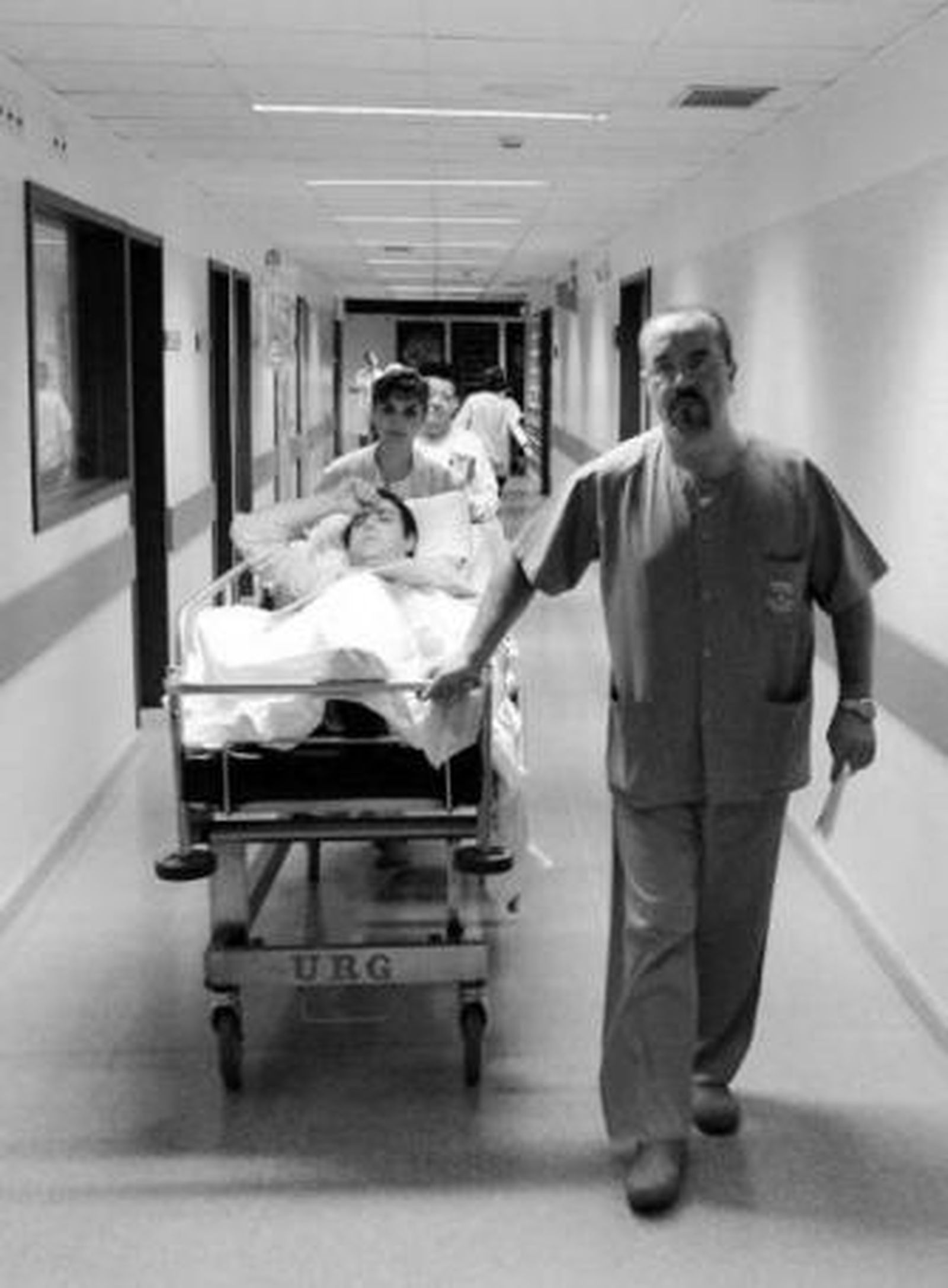 Un trabajador del Reina Sofía traslada a un paciente en una camilla.