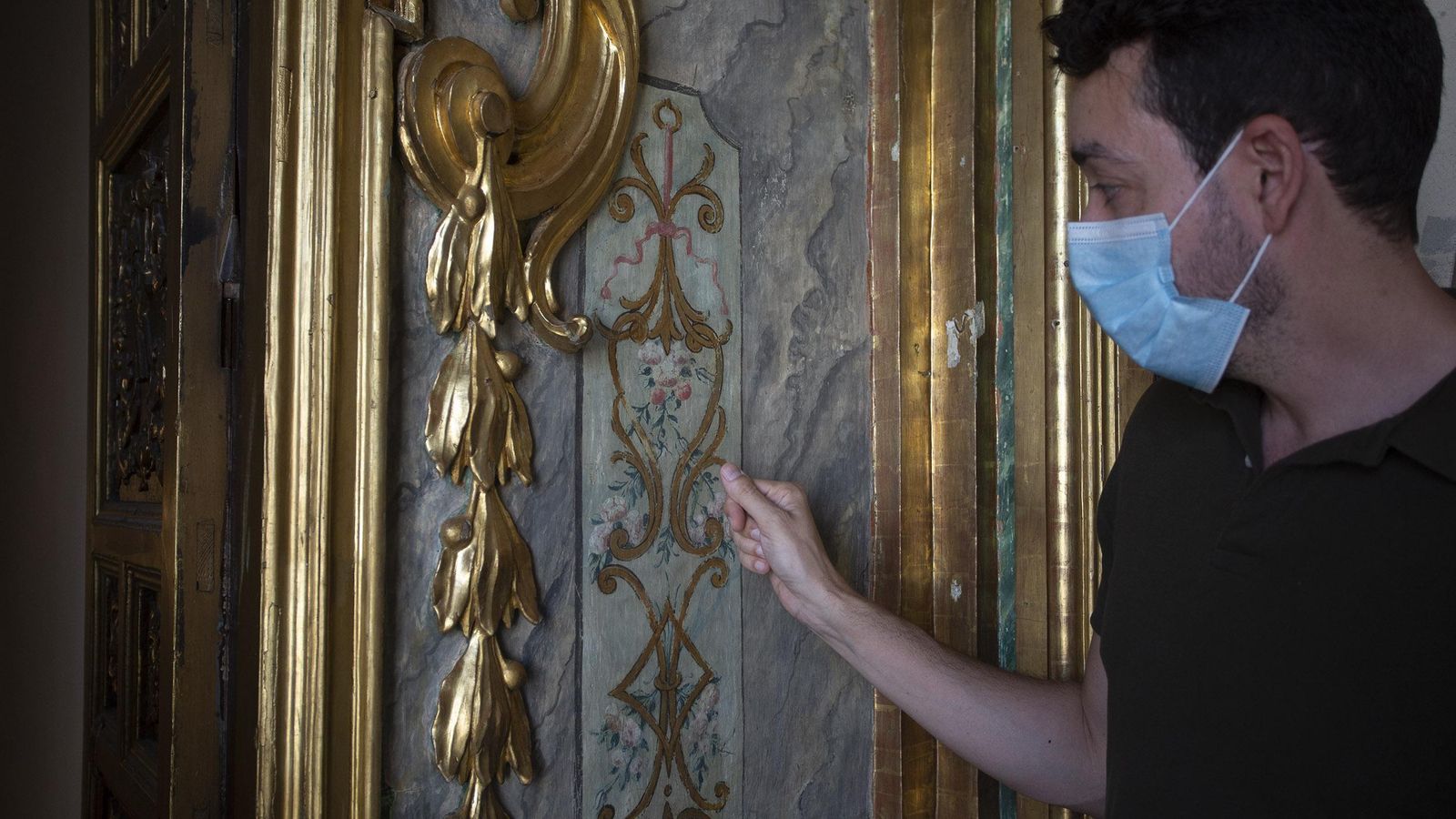 El historiador del Arte señala las pinturas murales que se han recuperado.