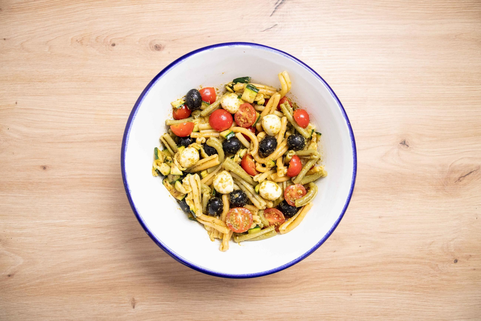 Ensalada de pasta tricolor con calabacín, cherry y pesto.