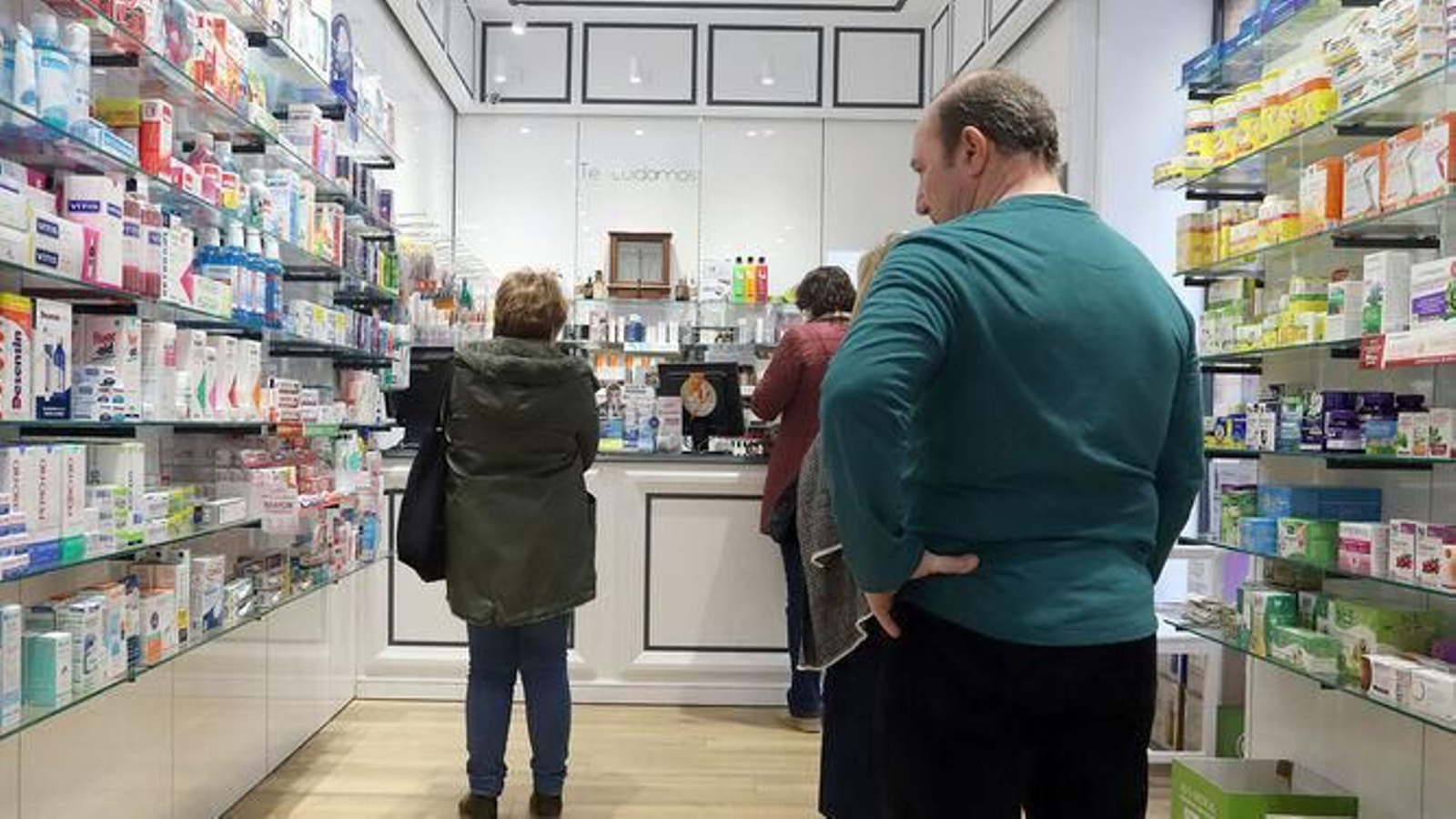 Varias personas hacen cola en una farmacia de la capital onubense.