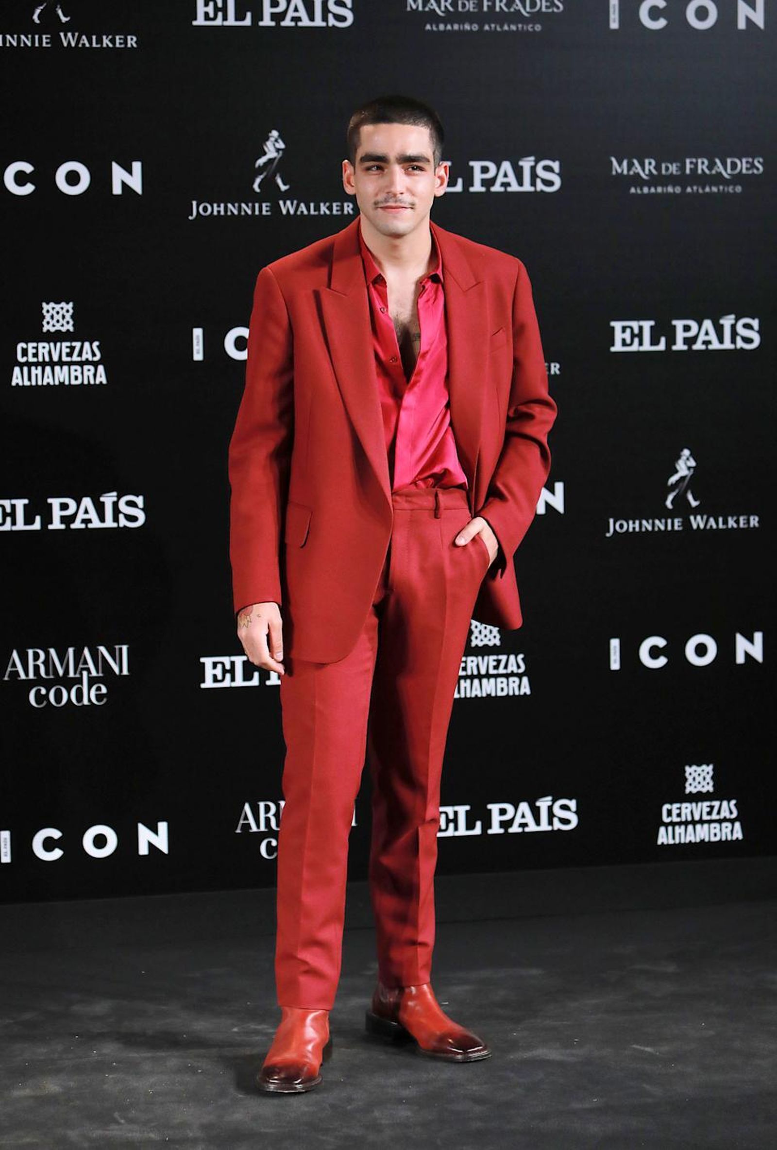 Omar Ayuso, en un 'photocall', con llamativo traje rojo y camisa rosa.