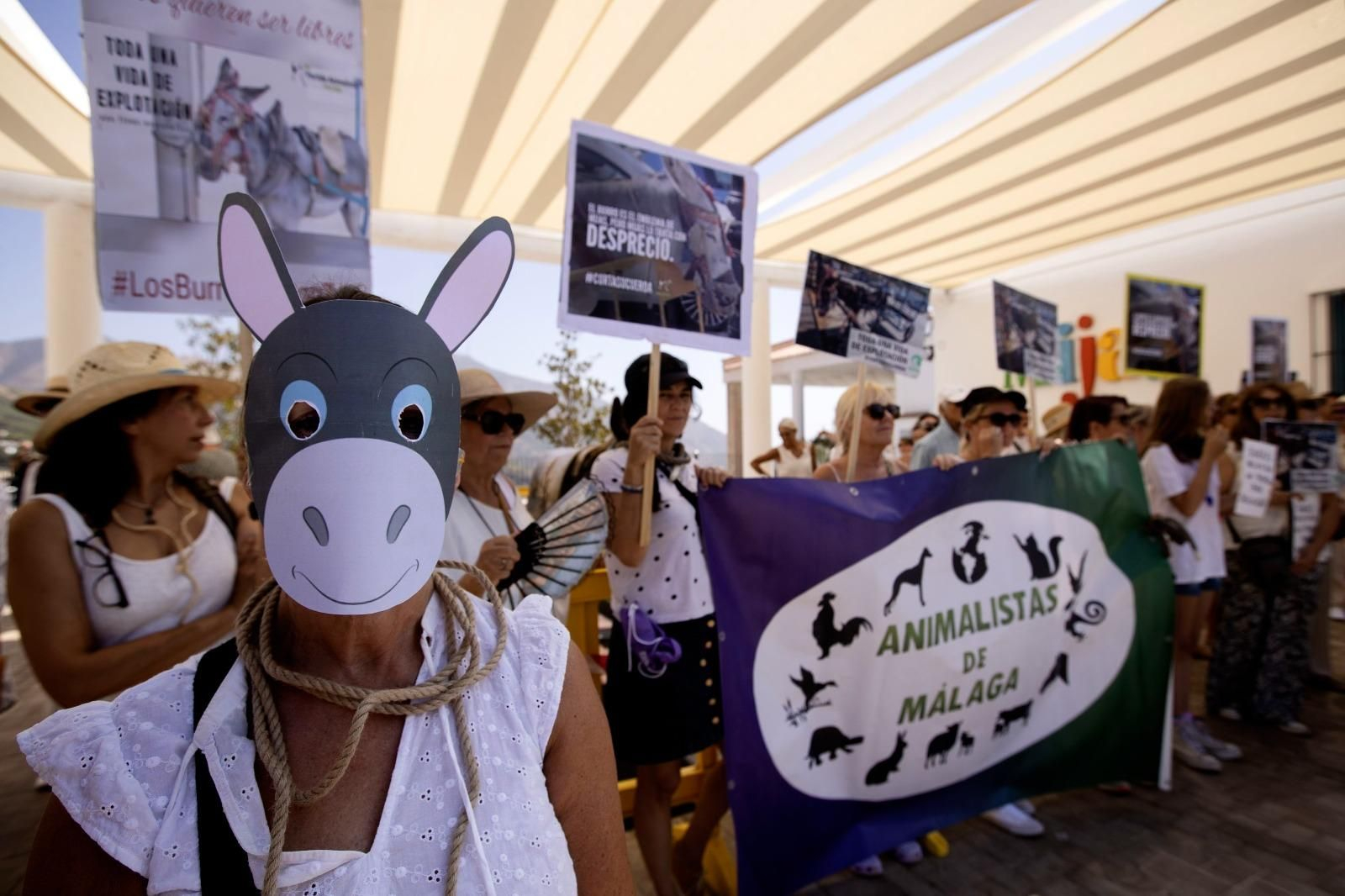 El grupo de animalistas manifestandose en Mijas vestidos con caretas y cuerdas