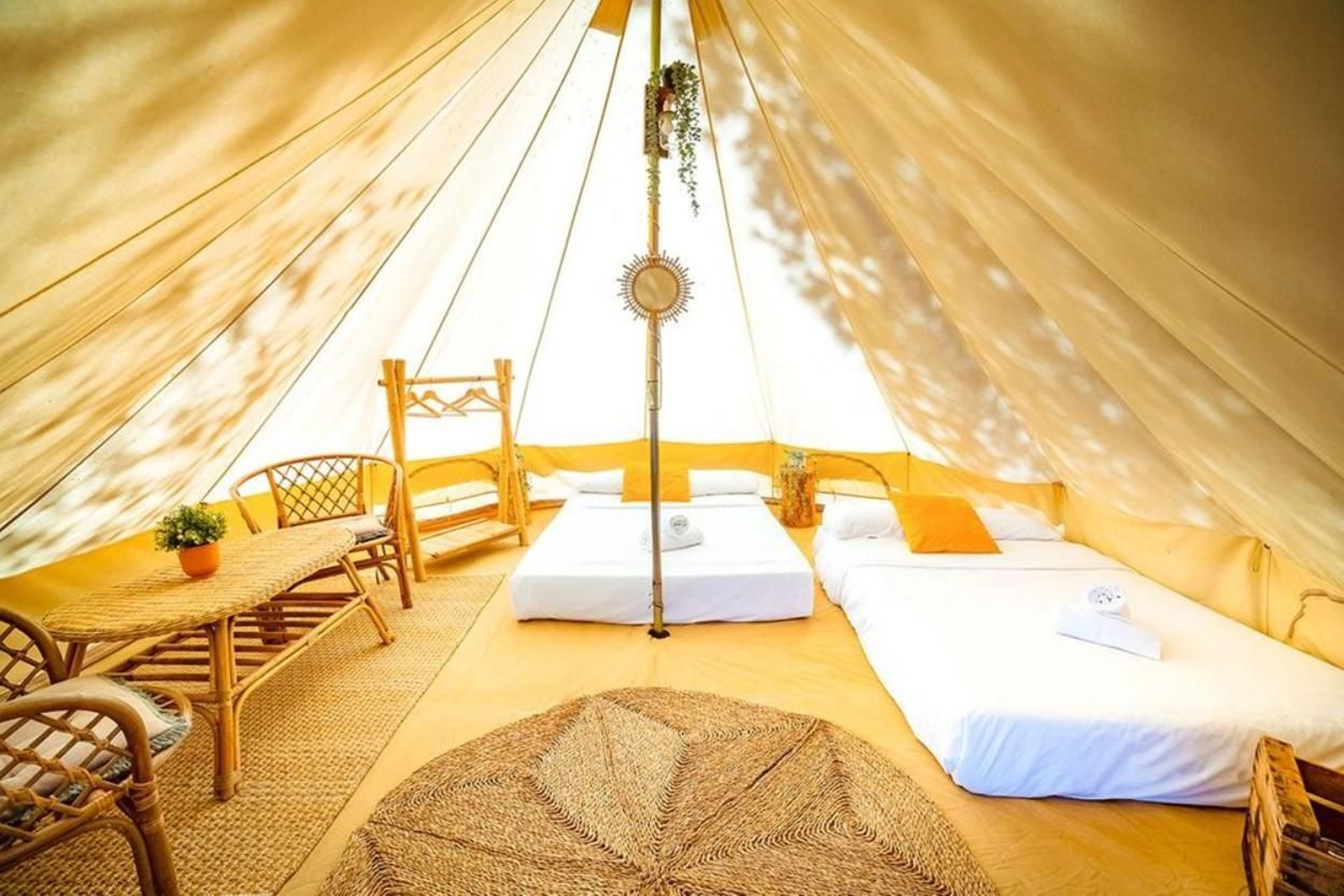 Interior de una tienda de glamping doble, con dos camas y el mobiliario que necesitas.