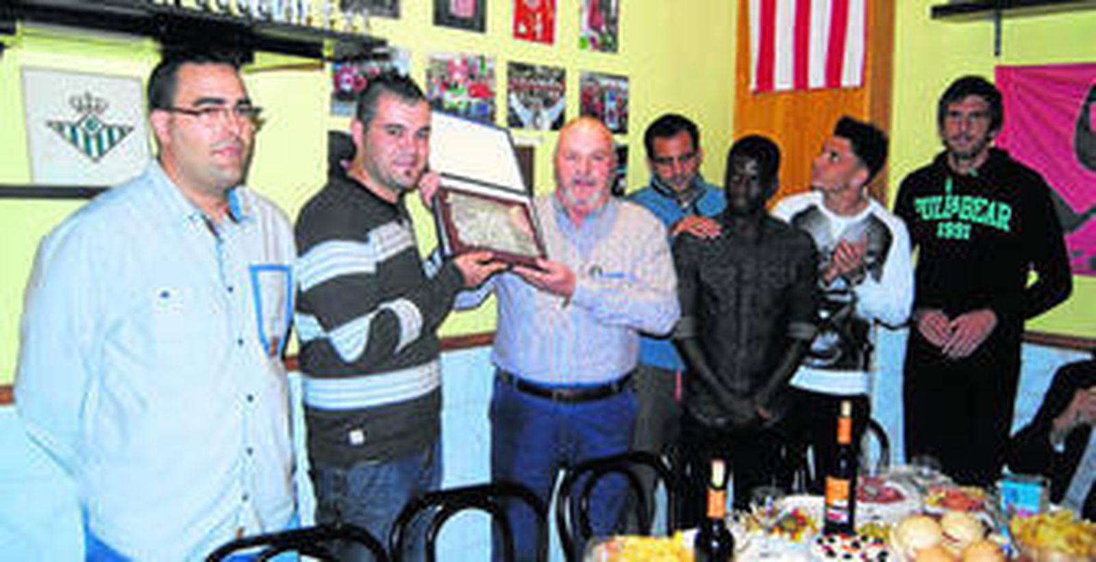 La peña 'Viator' entrega una metopa de recuerdo de la inauguración de la sede de 'Sentimiento Rojiblanco' con Verza, Azeez, Ximo y Julián en primera fila.