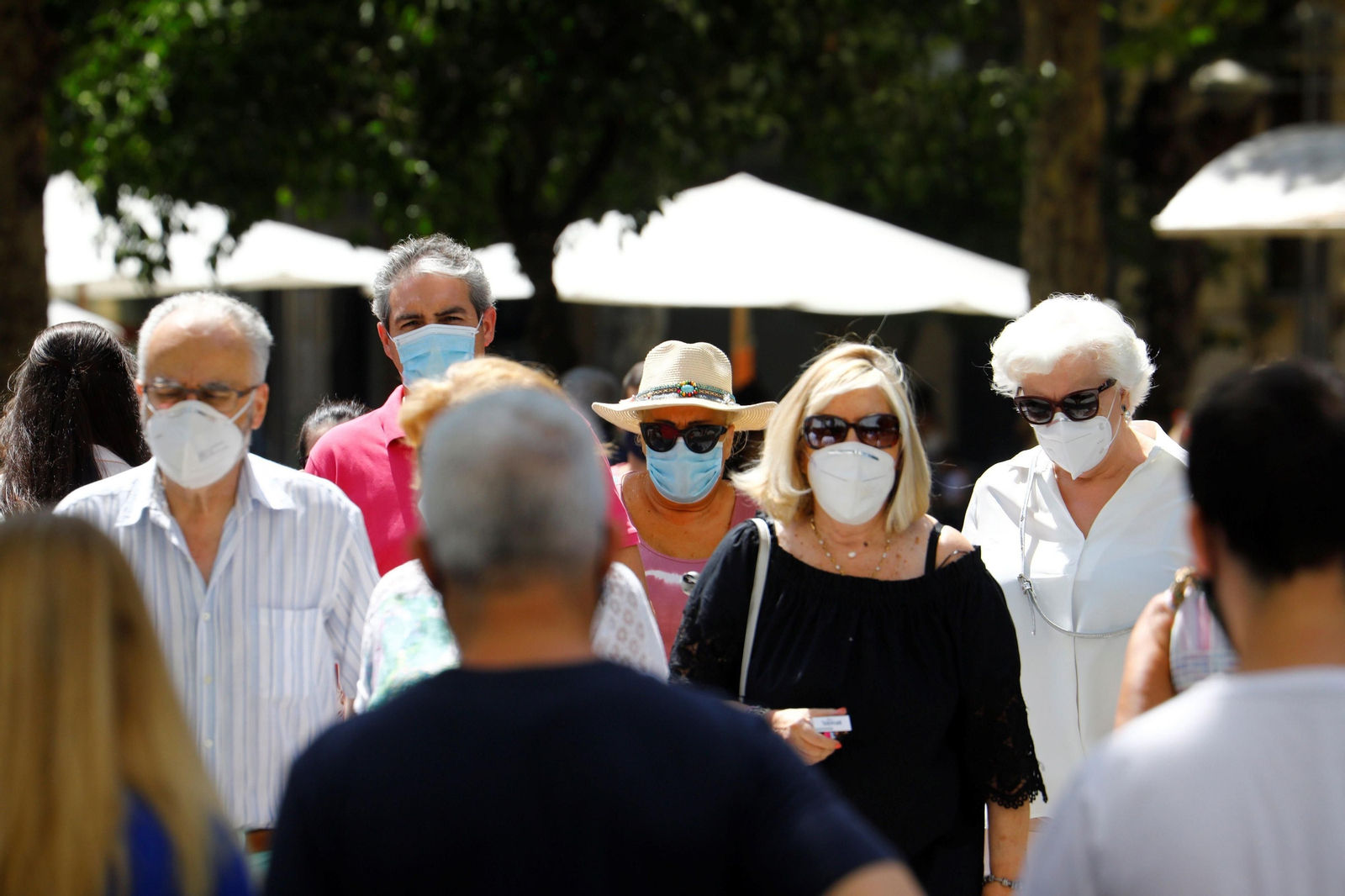 Varias personas caminan por el centro de Córdoba protegidas con mascarillas.