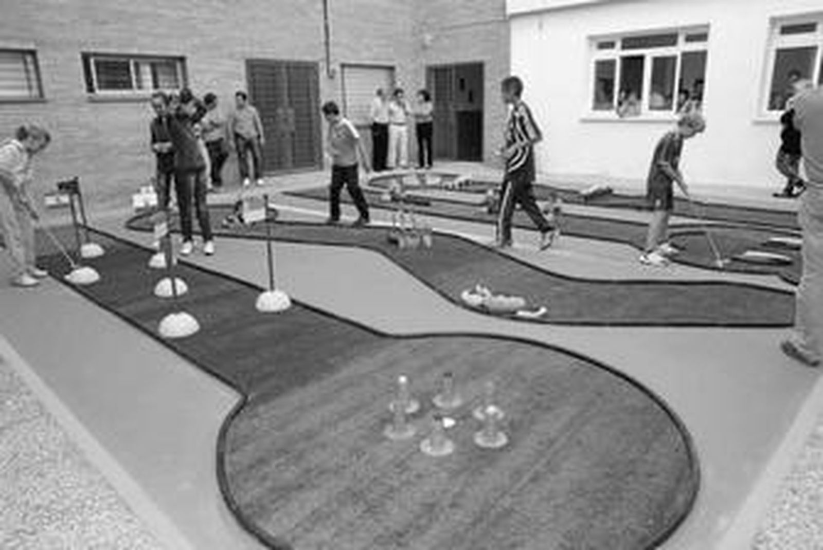 Varios niños juegan en las pistas de mini golf del colegio San Bernardo de la Estación.