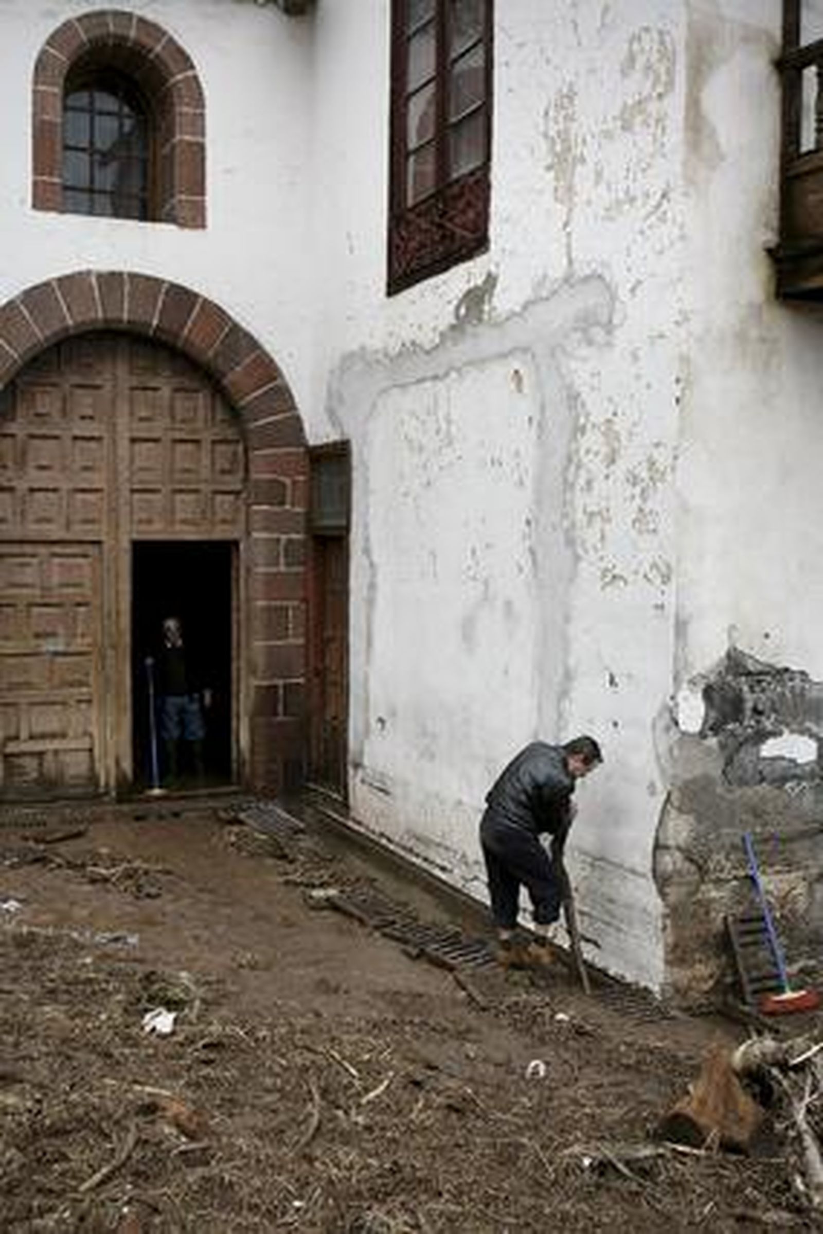 Un hombre desatasca las alcantarillas de la iglesia de La Concepción de Santa Cruz, inundada tras desbordarse el barranco de Santos por las intensas lluvias caídas en Tenerife.

Foto: Cristóbal García (Efe)