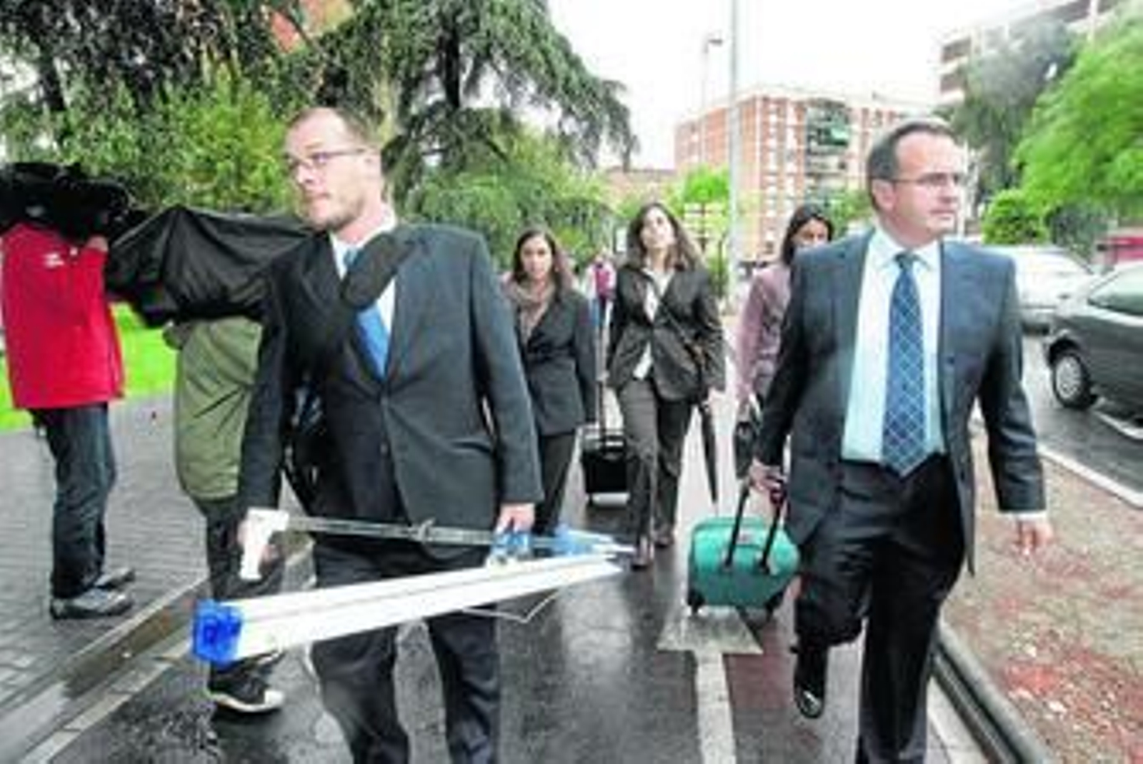 Algunos de los expertos participantes salen de los juzgados con un proyector.