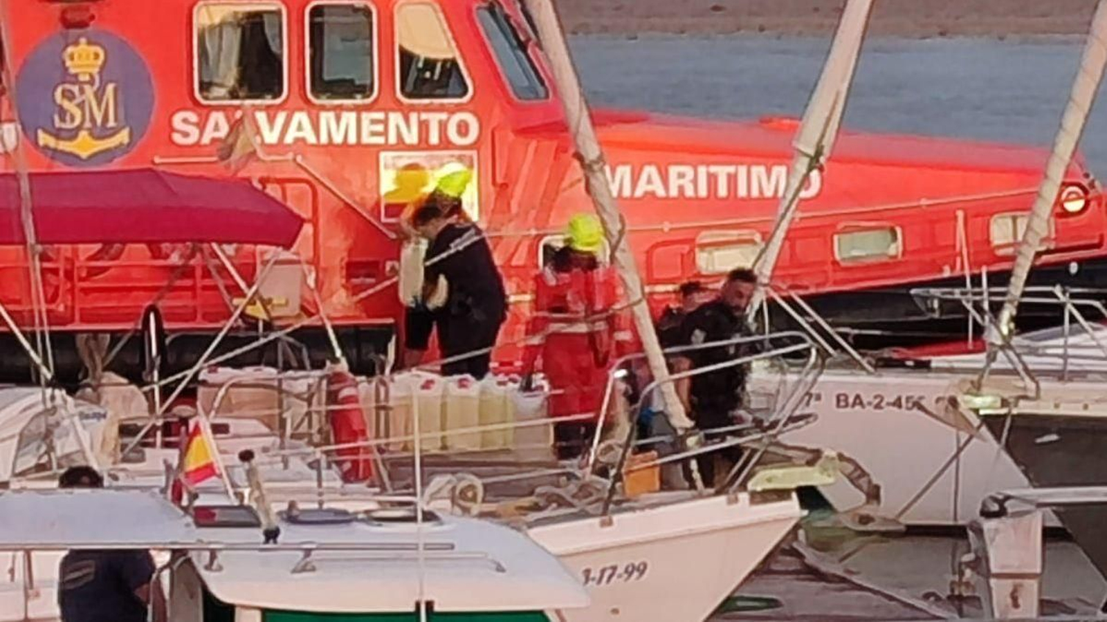 Los agentes, desembarcando las garrafas vacías de combustible.