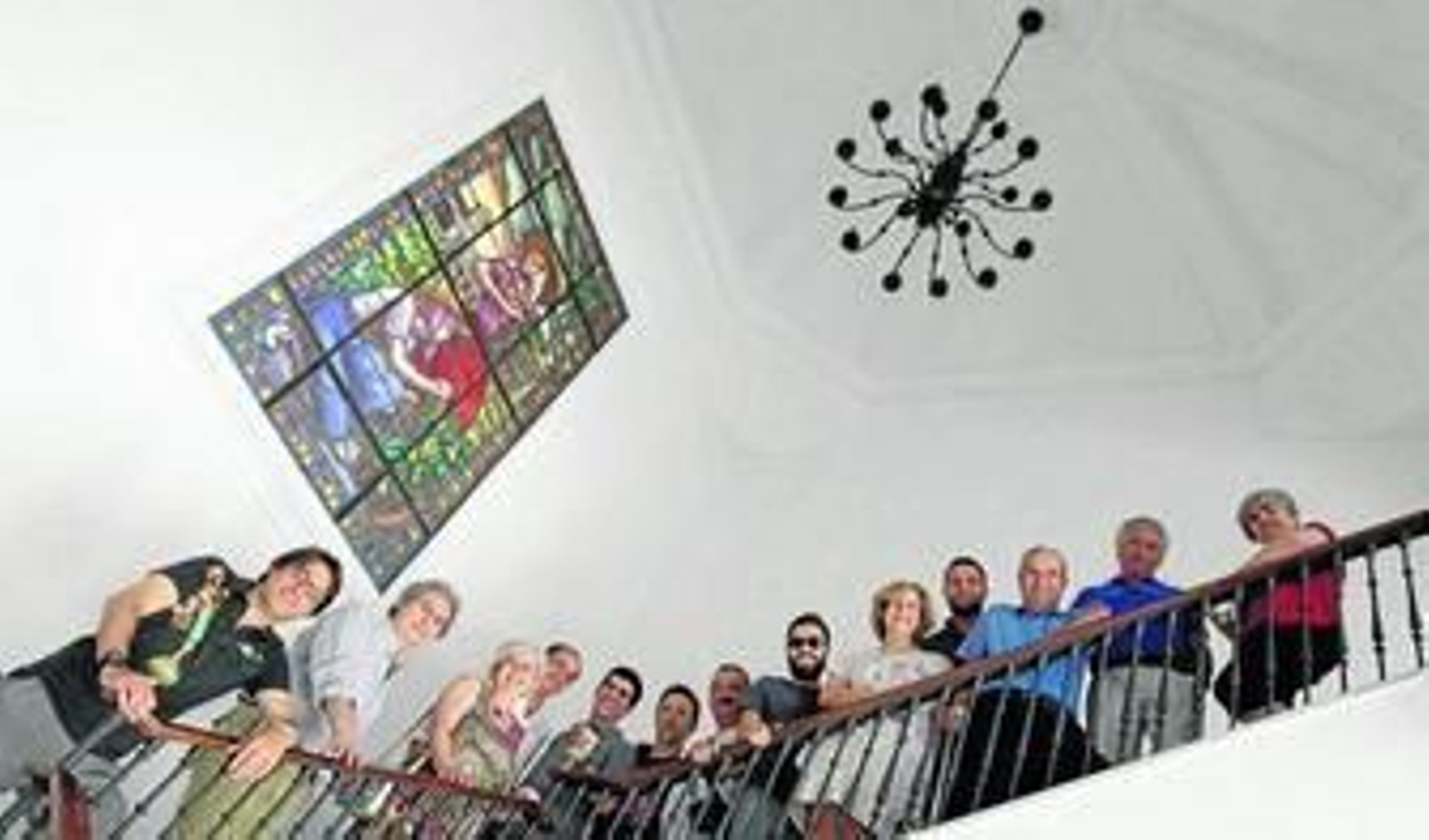 Algunos de los artistas participantes en la muestra, en el Consejo Regulador junto a la vidriera obra de Manuel Valle.