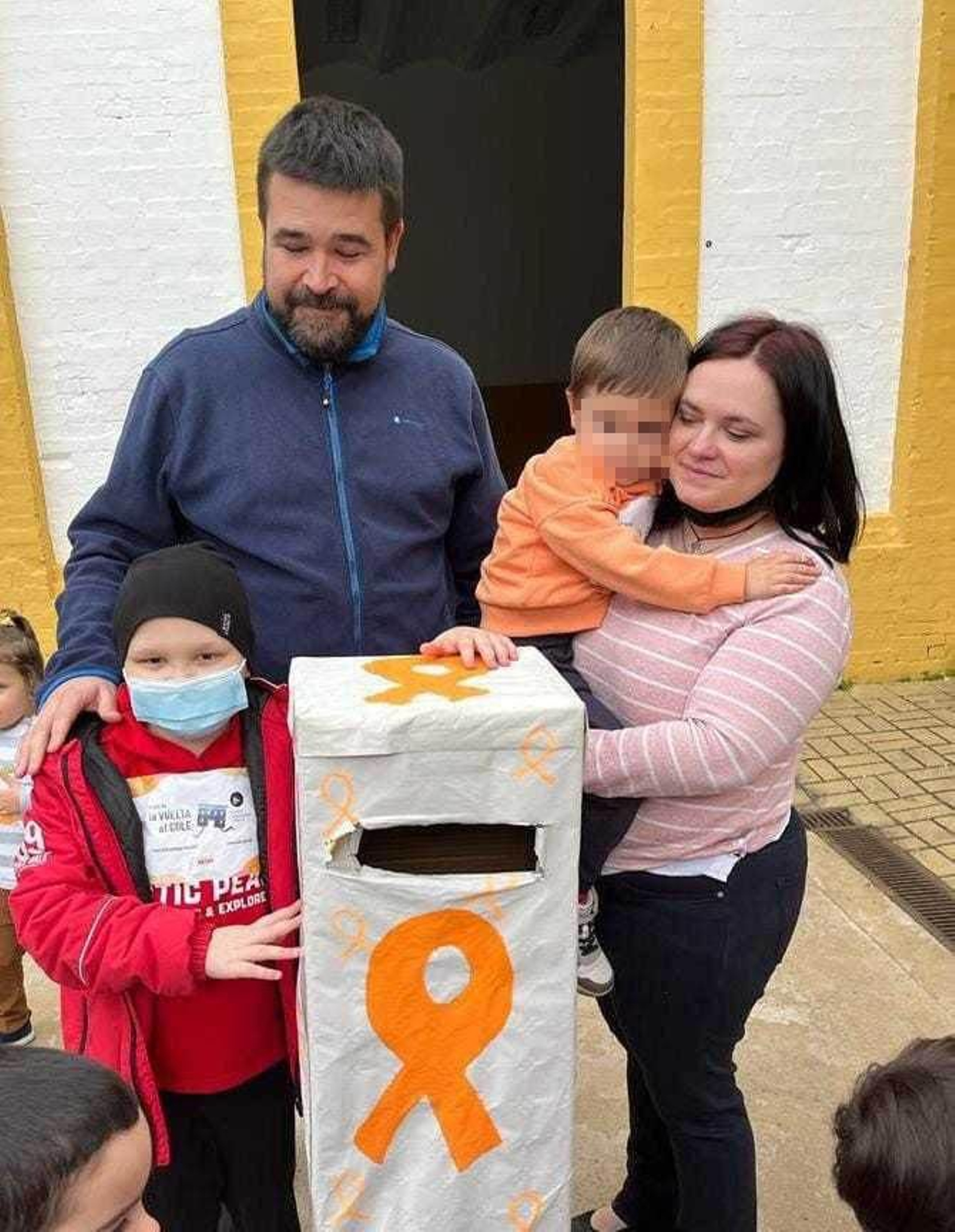 Gonzalo, sus padres y su hermano pequeño, junto al buzón donde se recogieron los donativos.