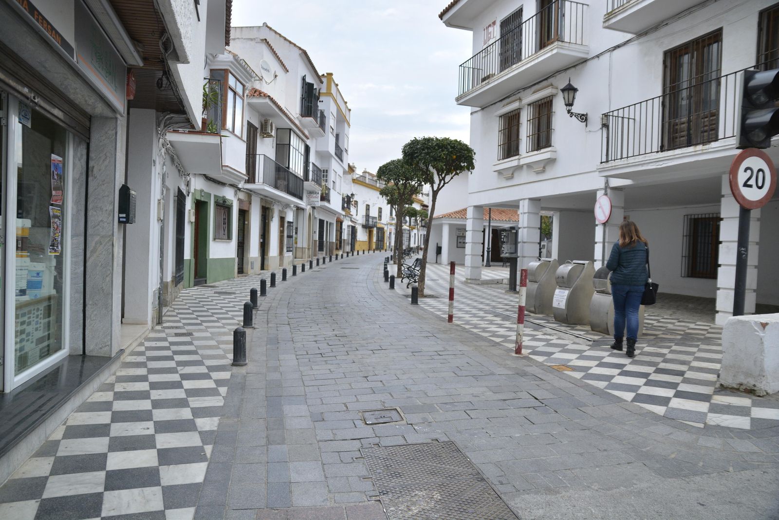 Una mujer camina por la calle Málaga.