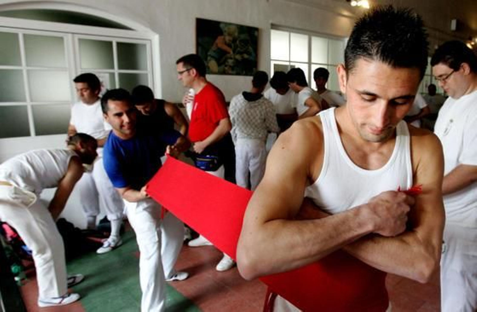 Un costalero ayuda a otro a fajarse en las dependencias de la Escuela de San José.

Foto: Pascual