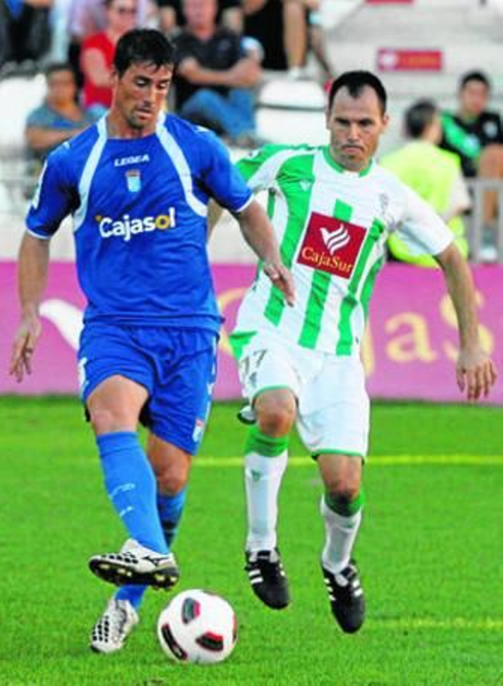 El ariete xerecista Mario Bermejo toca el balón ante el acoso del defensa blanquiverde Gerardo.