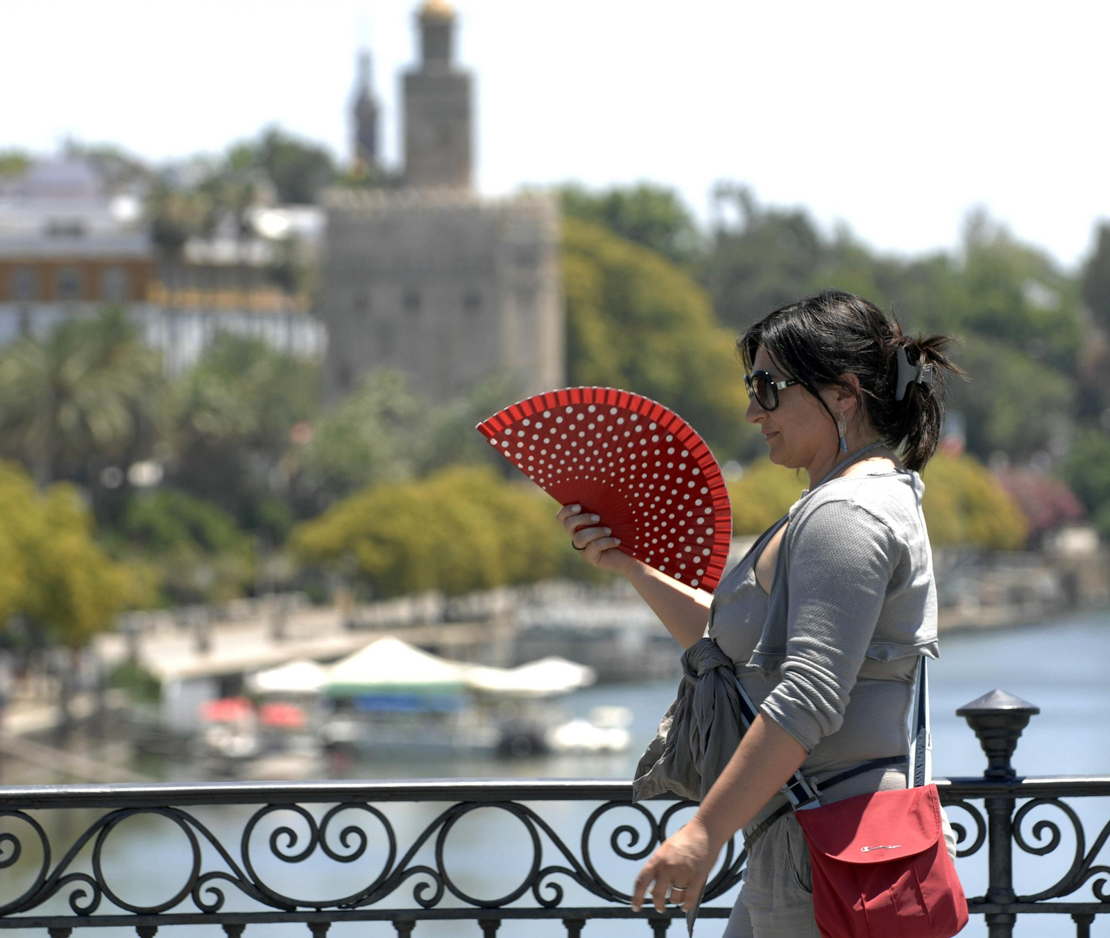 Una mujer se abanica para aliviar el calor en Sevilla.