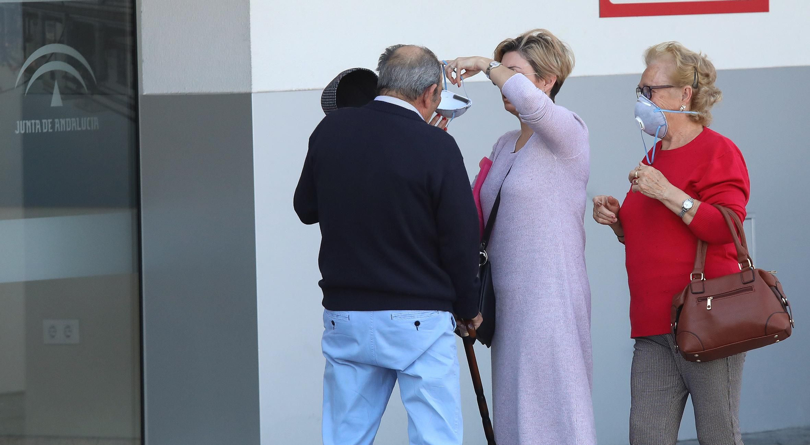 Usuarios se ponen mascarillas antes de acceder hoy al hospital de Jerez.