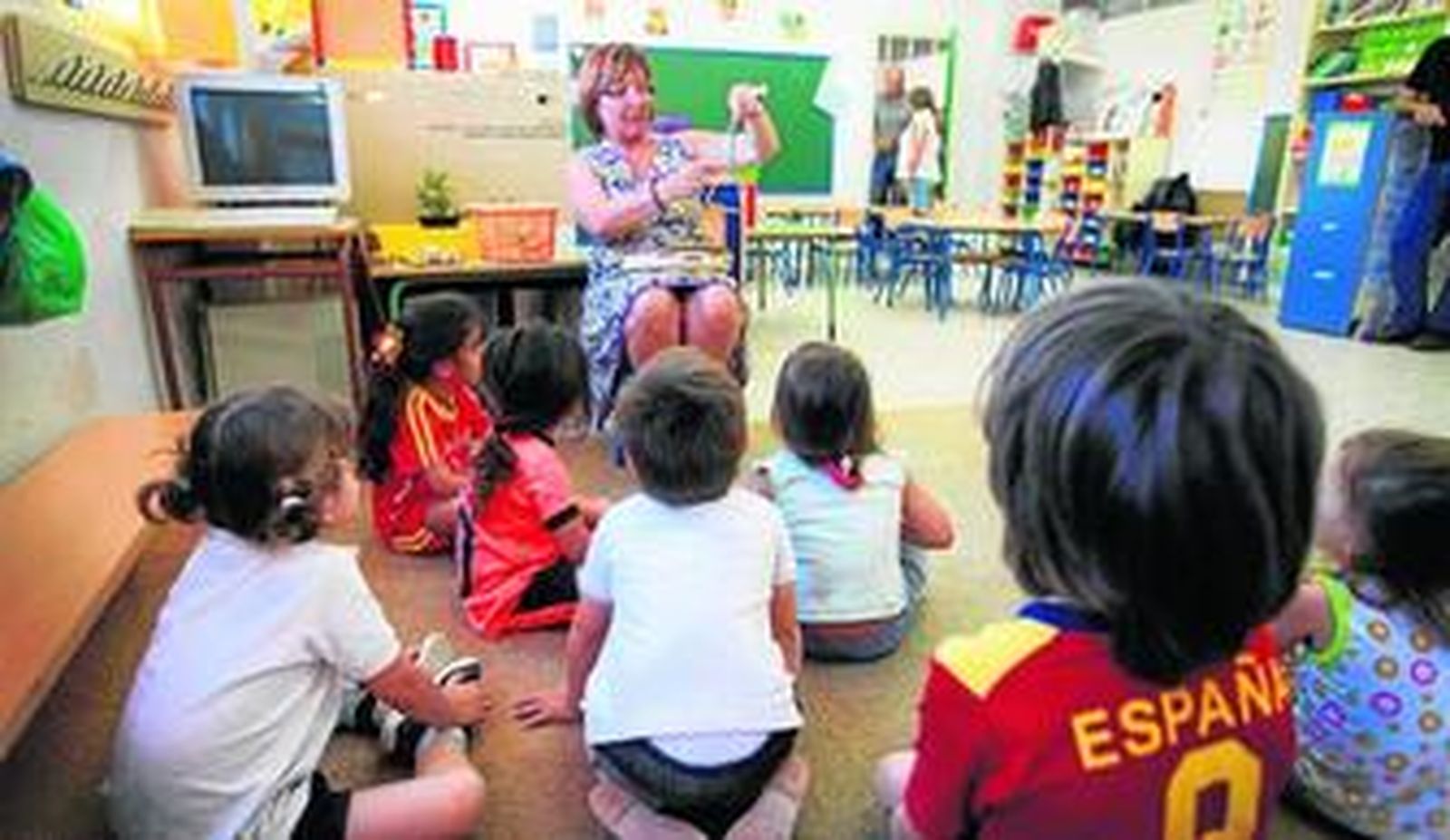 Una profesora trabajando con los niños en un aula de Infantil.
