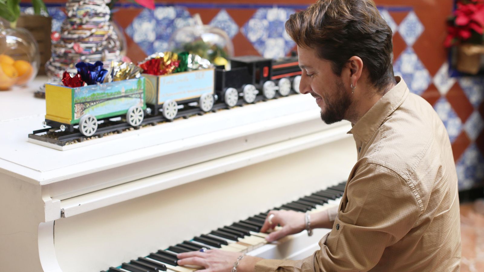 Manuel Carrasco toca el piano en momento de la entrevista.