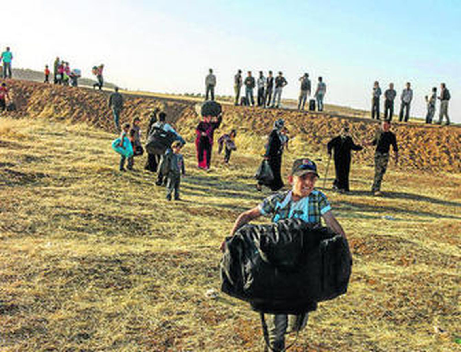 Un niño sirio porta una bolsa con algunas pertenencias en la frontera con Jordania.