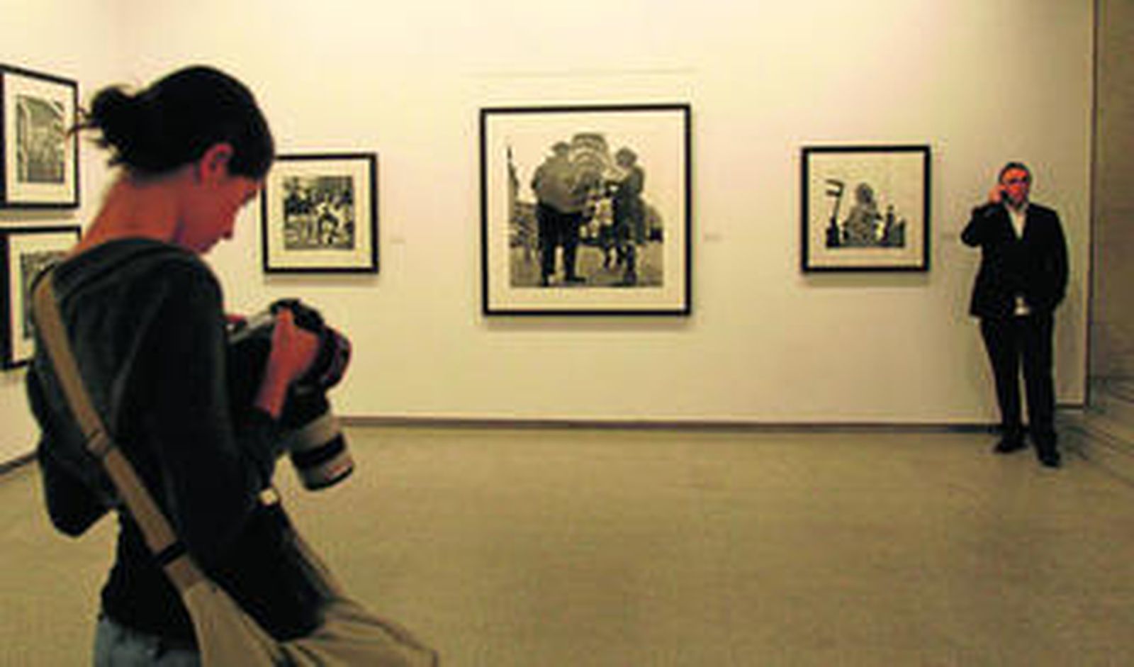 Una fotógrafa toma imágenes de la exposición en el Centro Cultural Cajasol, con el comisario de la misma, Chema Conesa, al fondo.