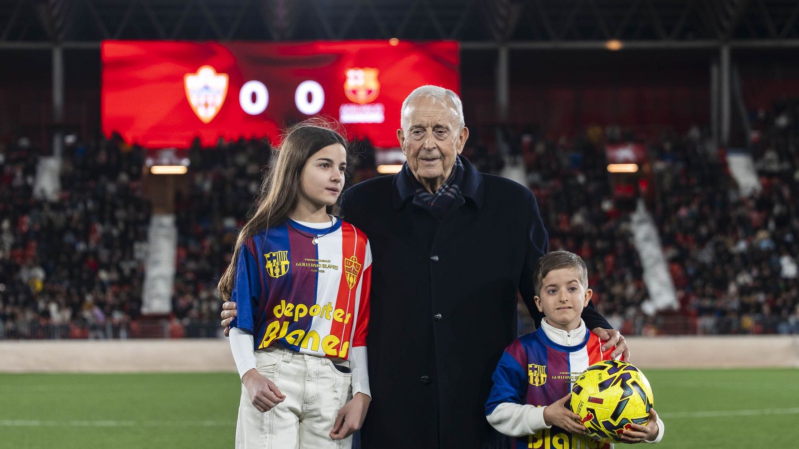 Guillermo Blanes junto a dos de sus nietos sobre el terreno de juego durante los prolegómenos del partido.