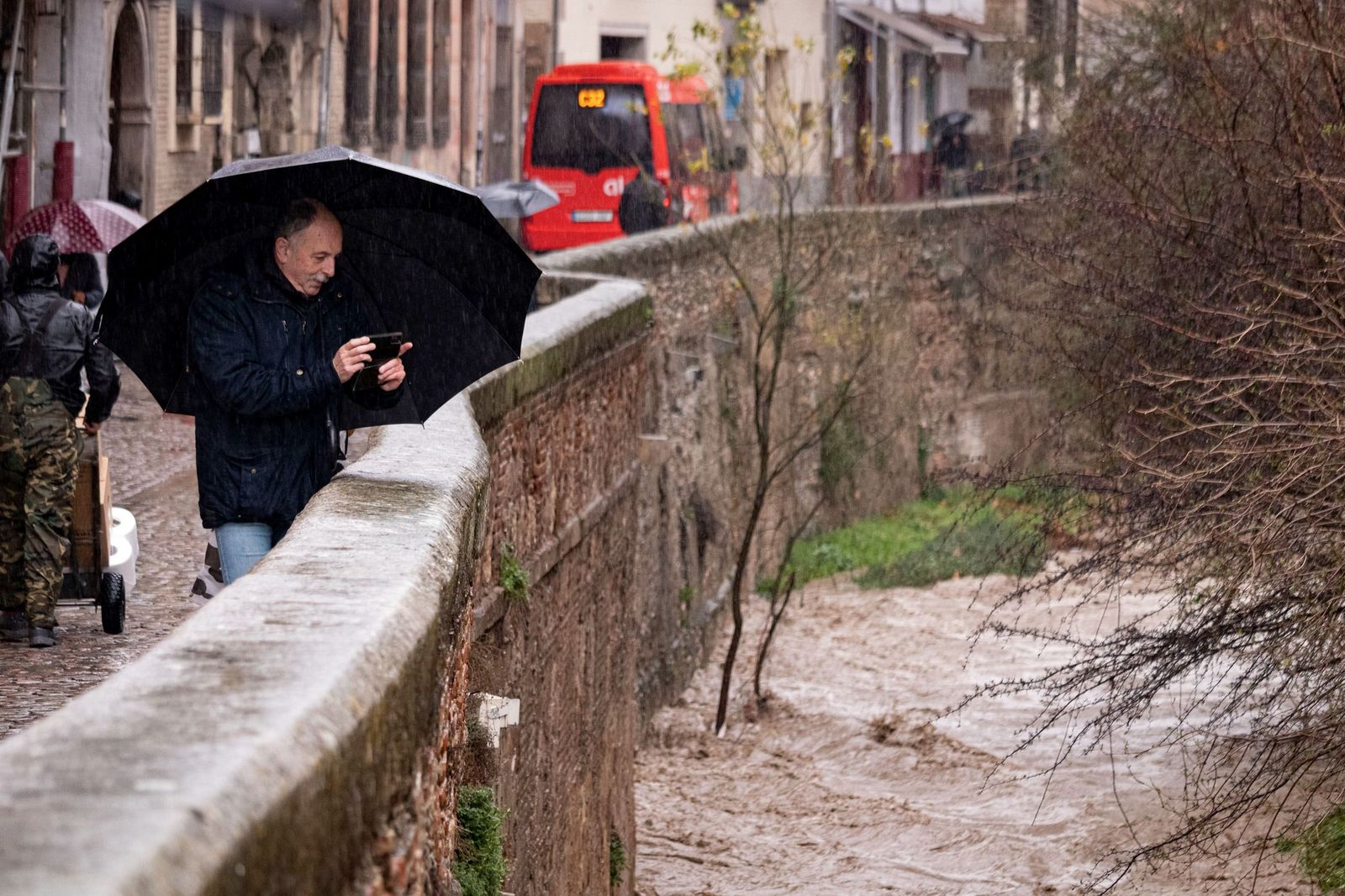 Un hombre fotografía el Darro durante la borrasca el pasado miércoles