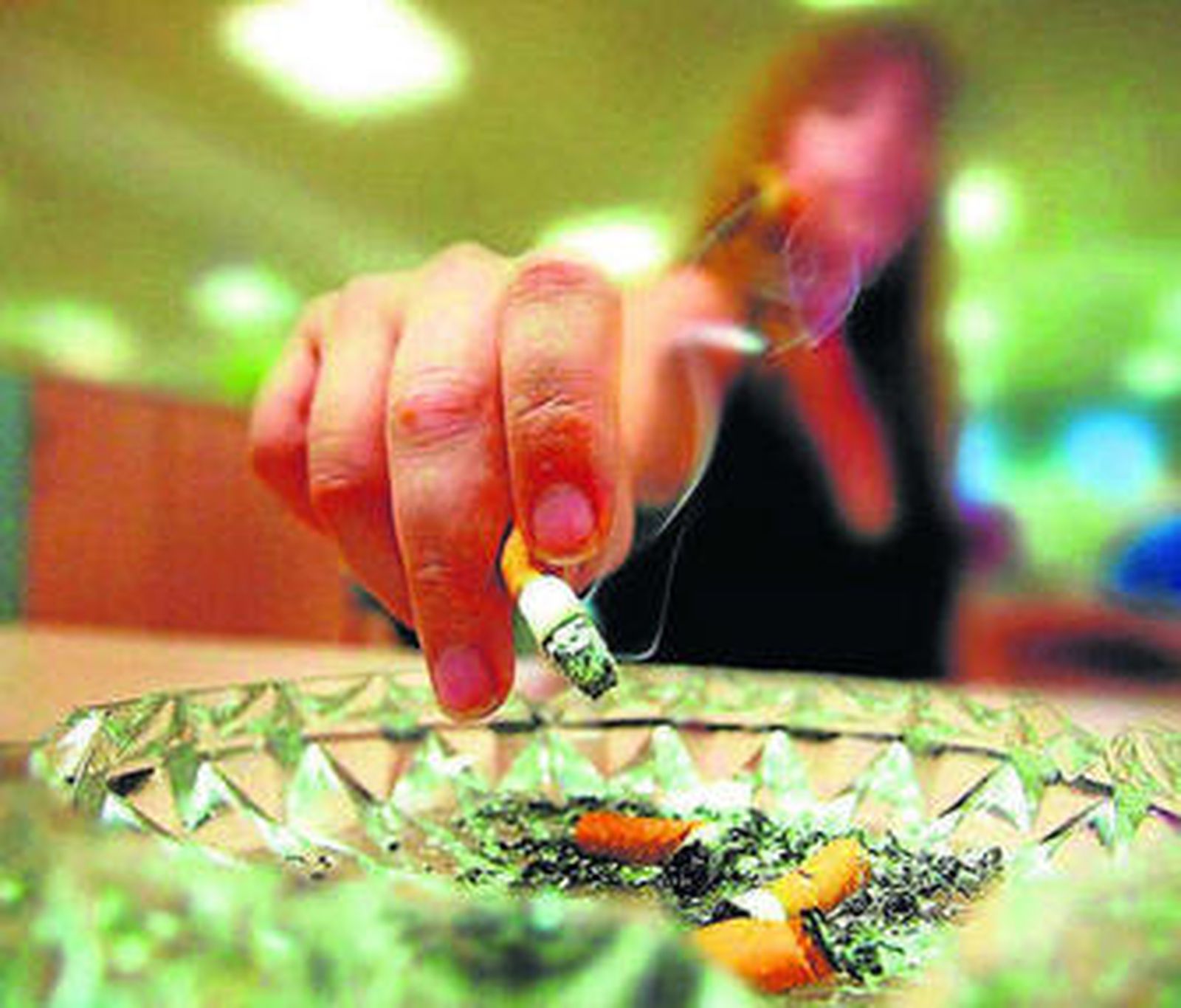 Una mujer apaga un cigarro.