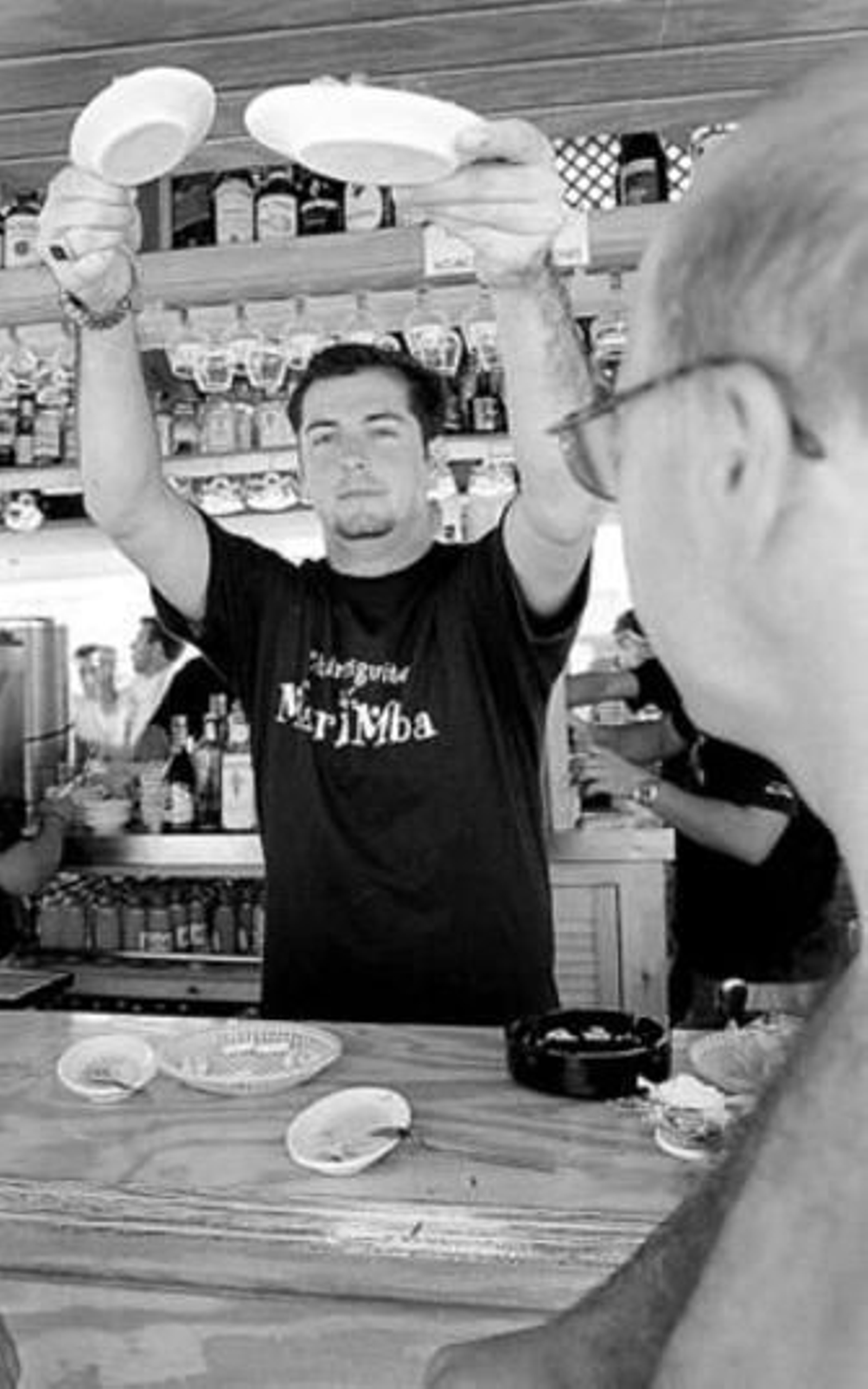 Un camarero de un chiringuito de la playa Victoria sirve unas tapas.