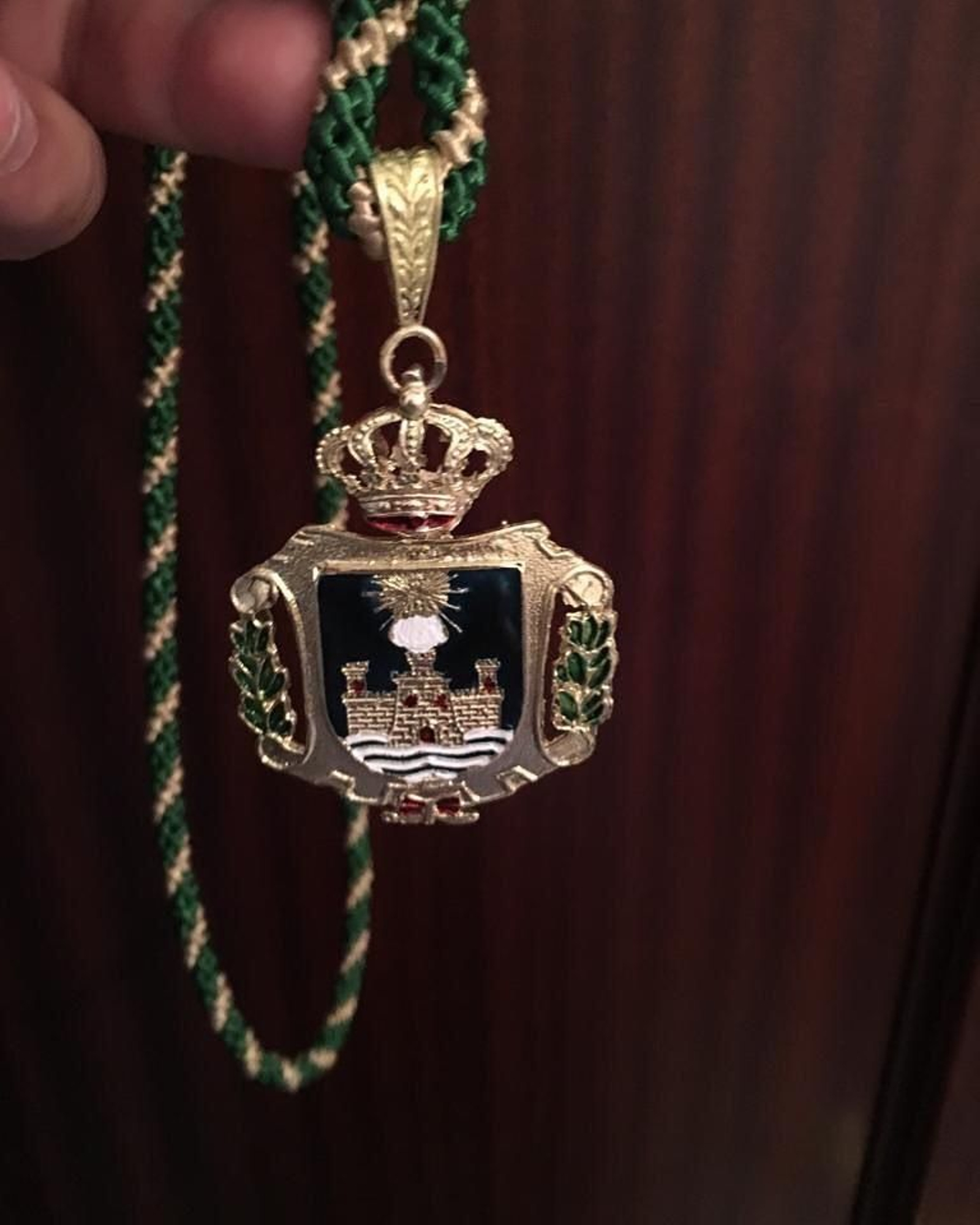 Imagen de una de las medallas con la imagen de la Virgen de Los Milagros tapada.