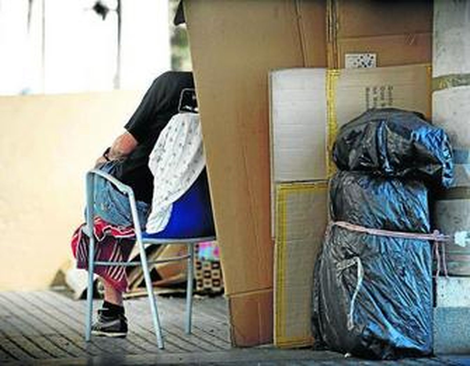 Unos cartones sirven para resguardar a una persona sin hogar.