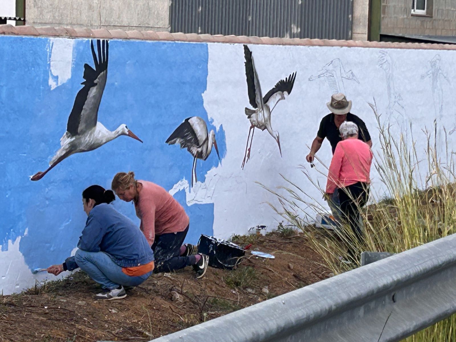 Varios vecinos pintando el mural esta semana.