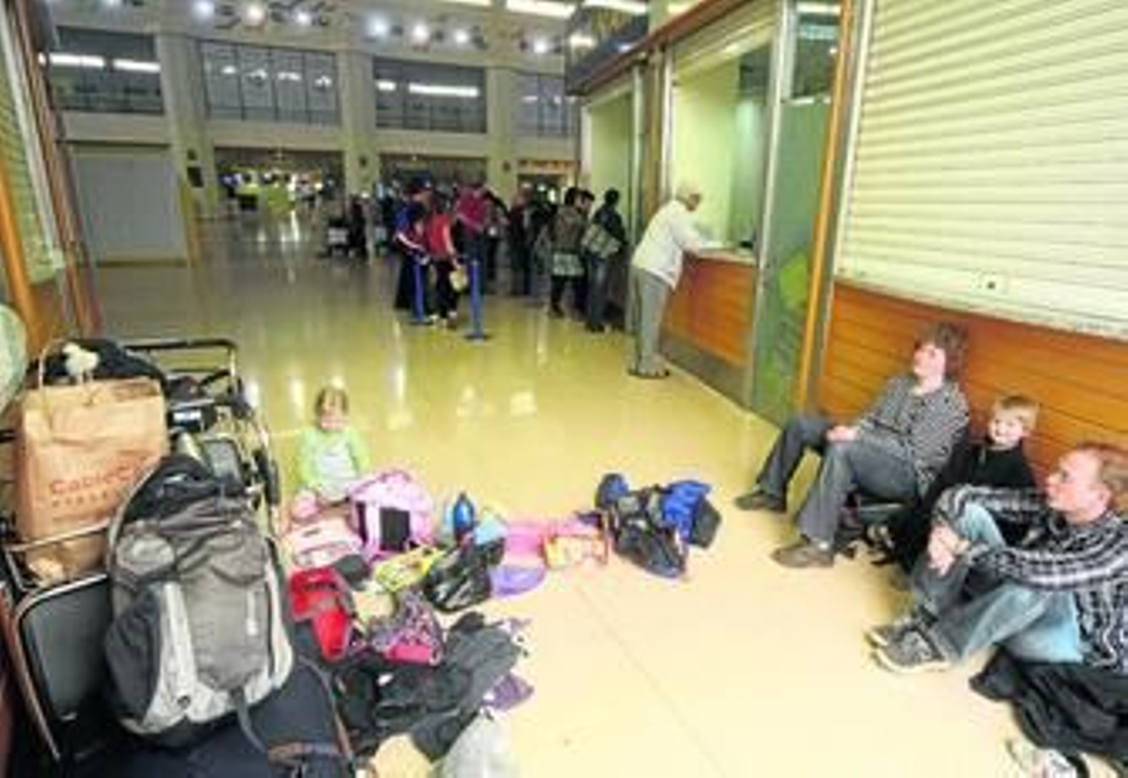 Una familia de turistas extranjeros, ayer, junto a uno de los mostradores de las compañías en el aeropuerto.