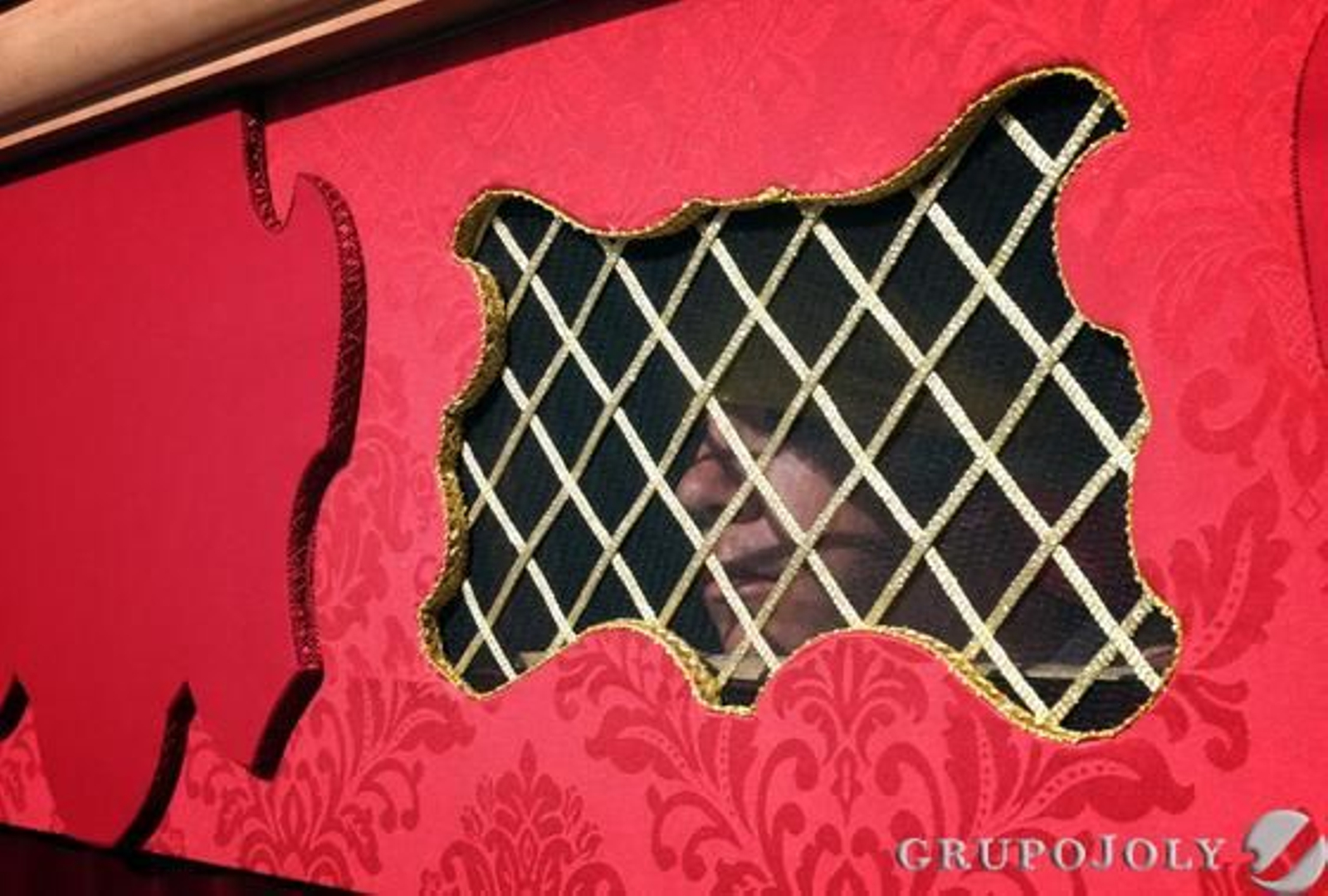 Un costalero de Humildad y Paciencia se deja entrever tras los respiraderos bordados del paso de la cofradía.

Foto: Manu Garcia