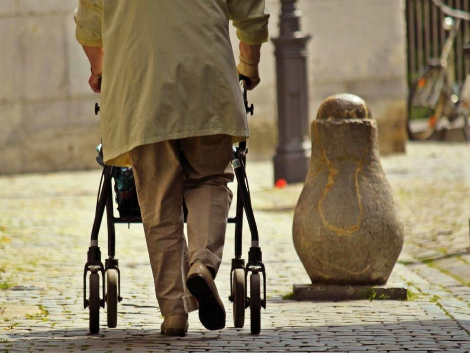 Un hombre camina ayudado por un carrito.