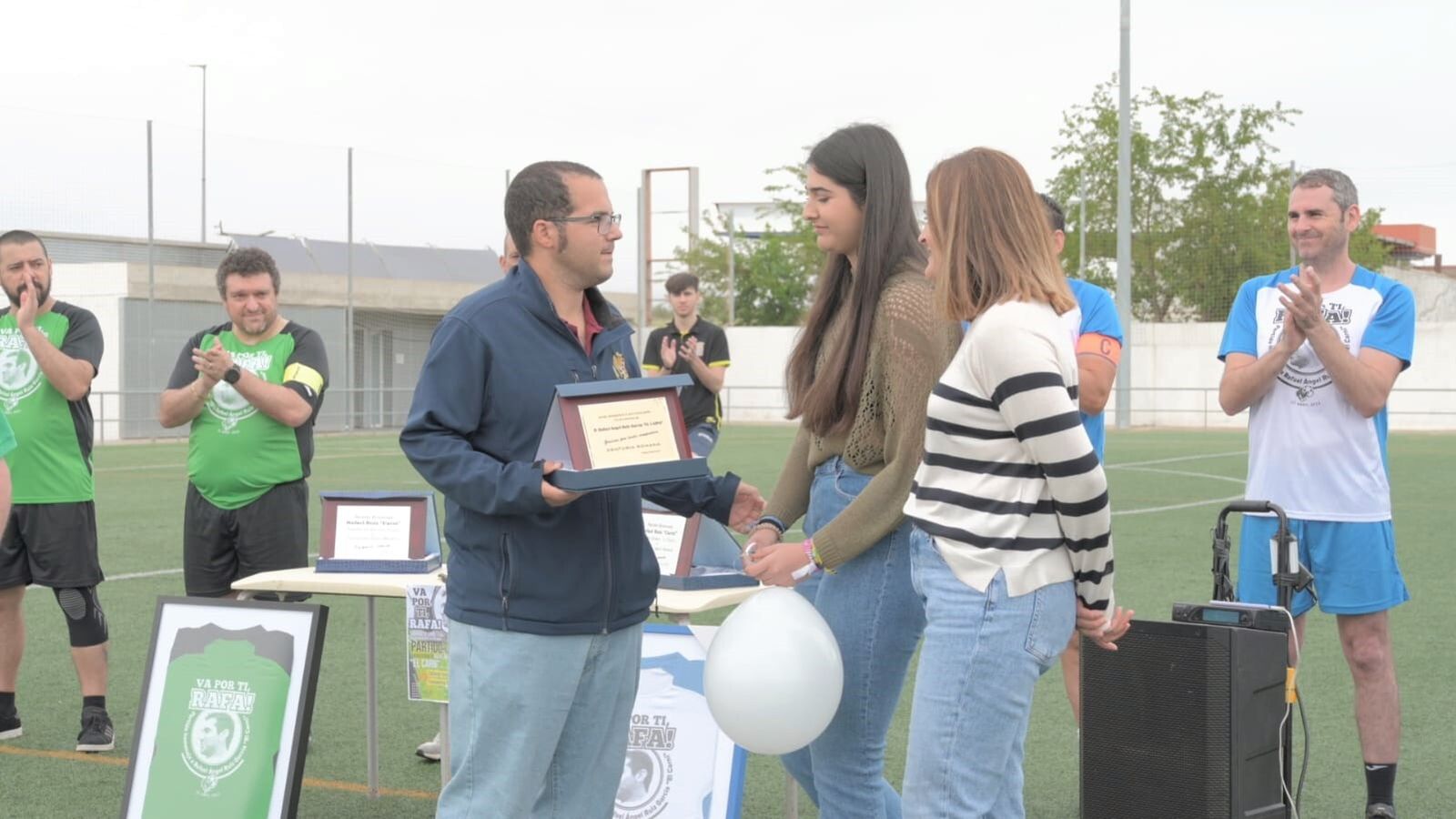 La hija y la mujer de Rafael Ángel recogen una placa en un momento del homenaje.
