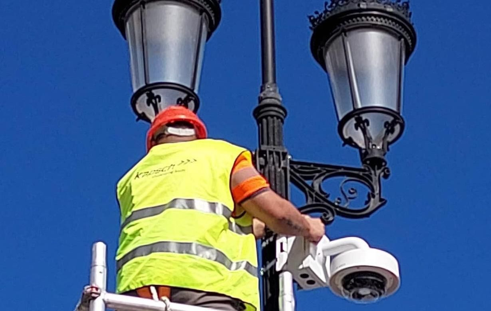 Un operario instala un videosensor en una farola.
